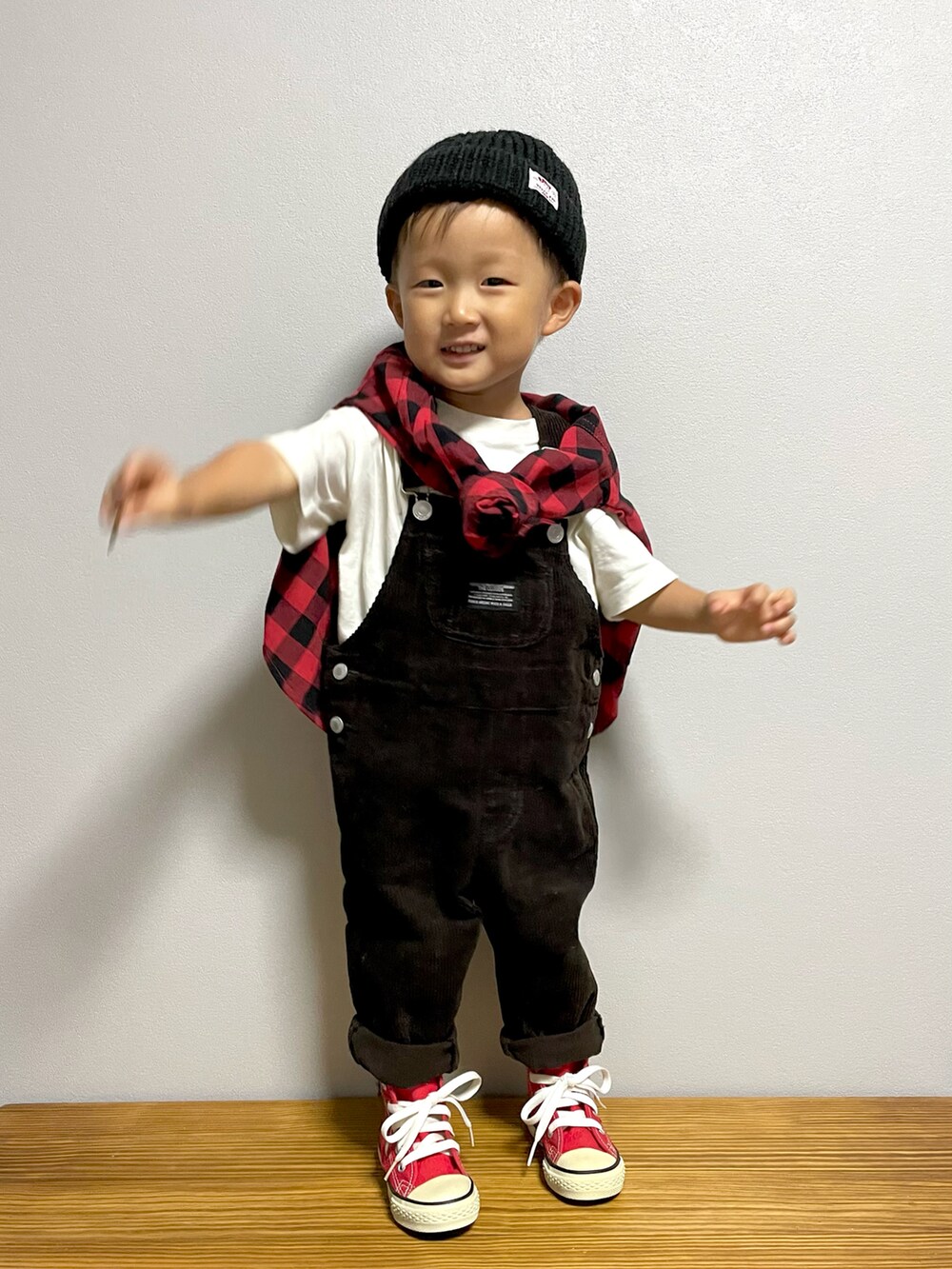 レッド系のシャツ/ブラウス、グレー系のサロペット/オーバーオール、レッド系のスニーカーを着用したキッズの秋コーディネートの2枚目の写真