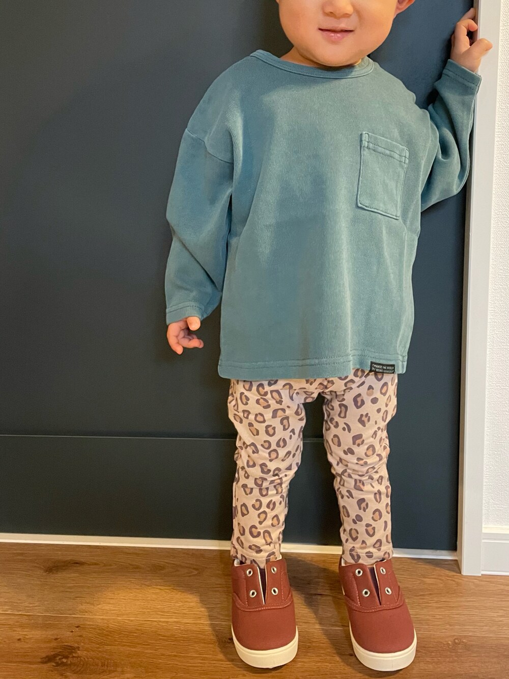 グリーン系のTシャツ/カットソー、ベージュ系のその他パンツ、レッド系のスニーカーを着用したキッズの冬コーディネートの2枚目の写真