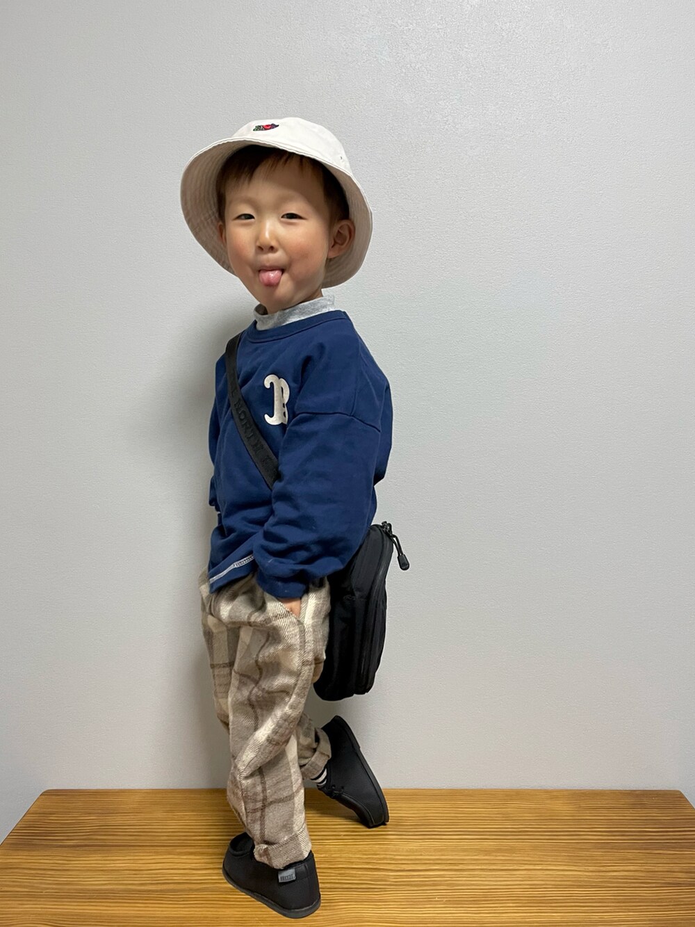 グリーン系のスウェット、ブラック系のブーツ、ブラック系のショルダーバッグを着用したキッズの春コーディネートの4枚目の写真