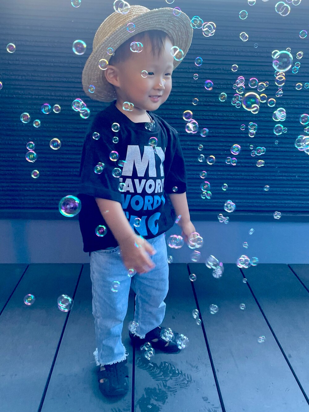 ブラック系のTシャツ/カットソー、ブルー系のデニムパンツ、ブラック系のサンダルを着用したキッズの夏コーディネートの4枚目の写真