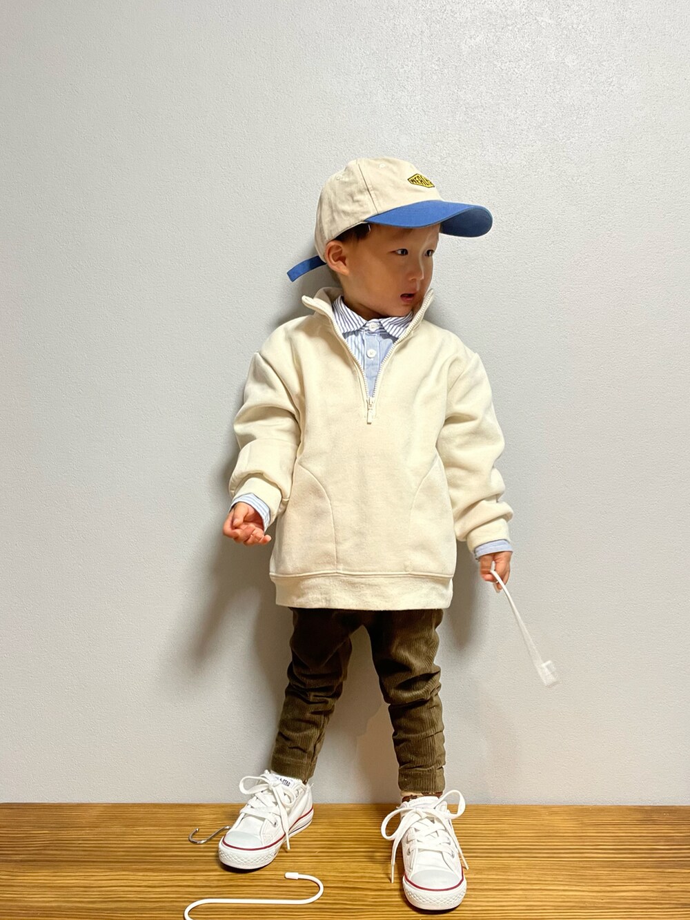 ホワイト系のスウェット、ブルー系のシャツ/ブラウス、ホワイト系のスニーカーを着用したキッズの秋コーディネートの2枚目の写真