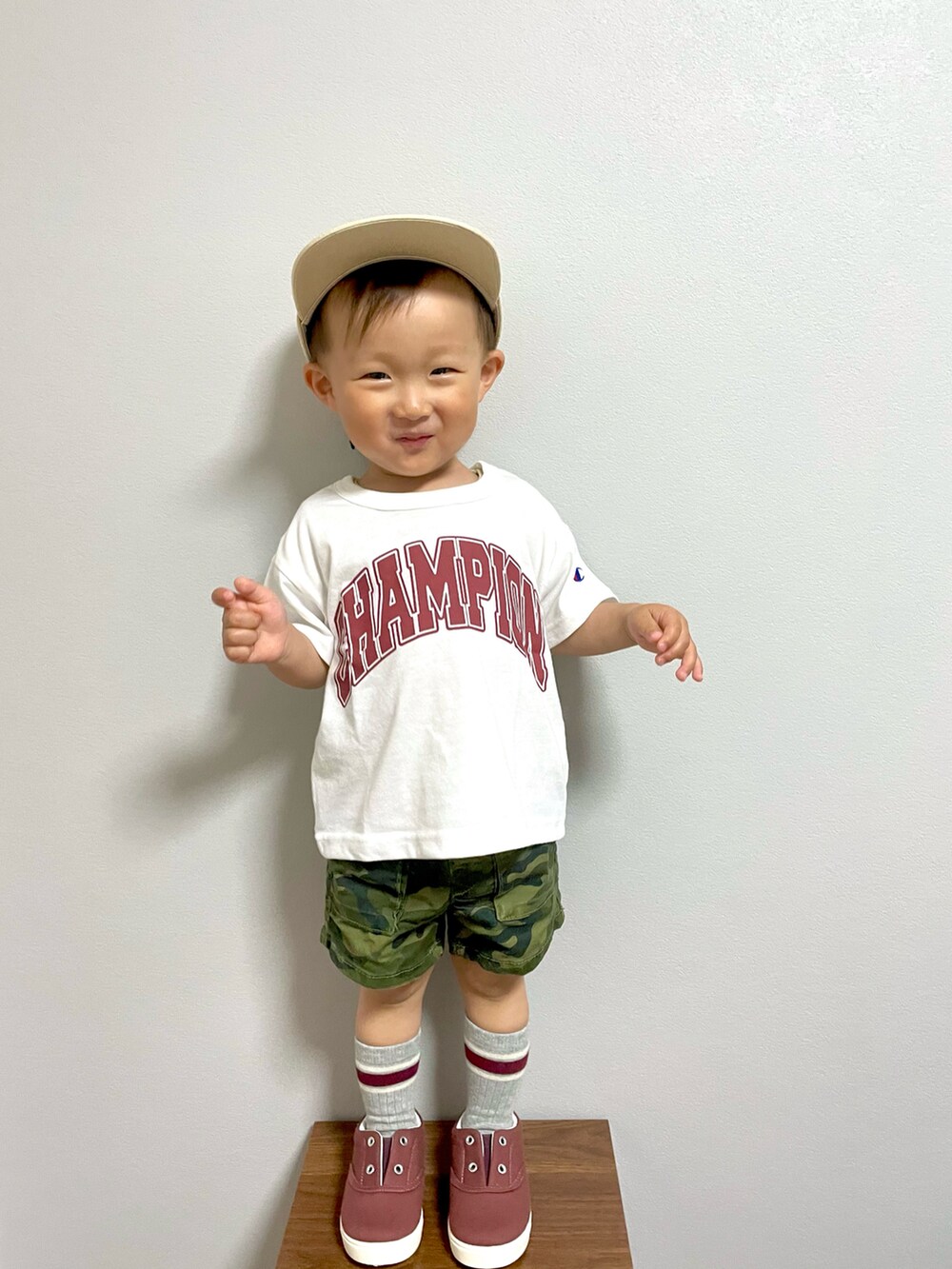 グリーン系のカーゴパンツ、レッド系のスニーカー、ベージュ系のキャップを着用したキッズの春コーディネートの3枚目の写真