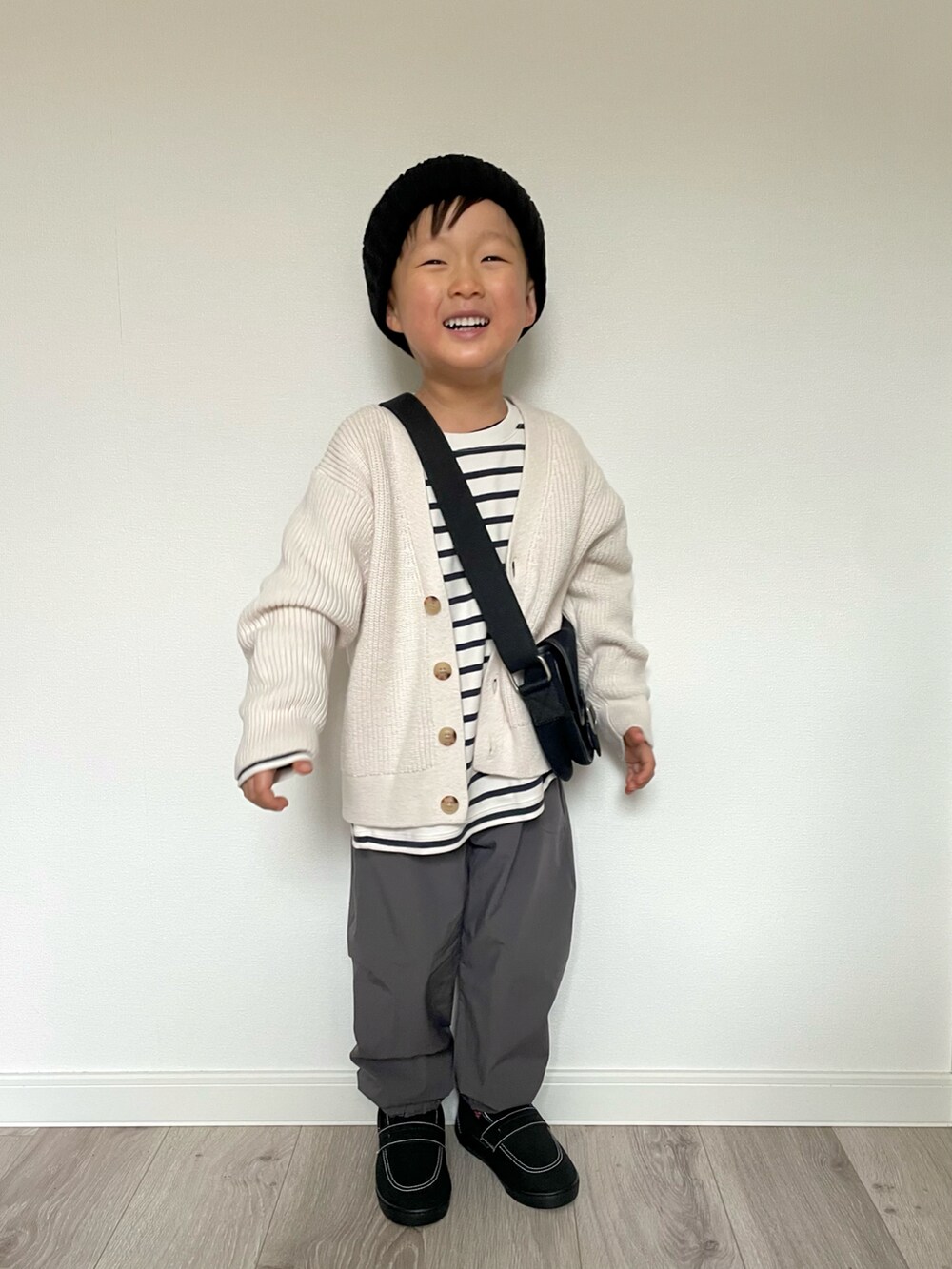 ホワイト系のTシャツ/カットソー、ホワイト系のカーディガン/ボレロ、ブラック系のショルダーバッグを着用したキッズの冬コーディネートの3枚目の写真