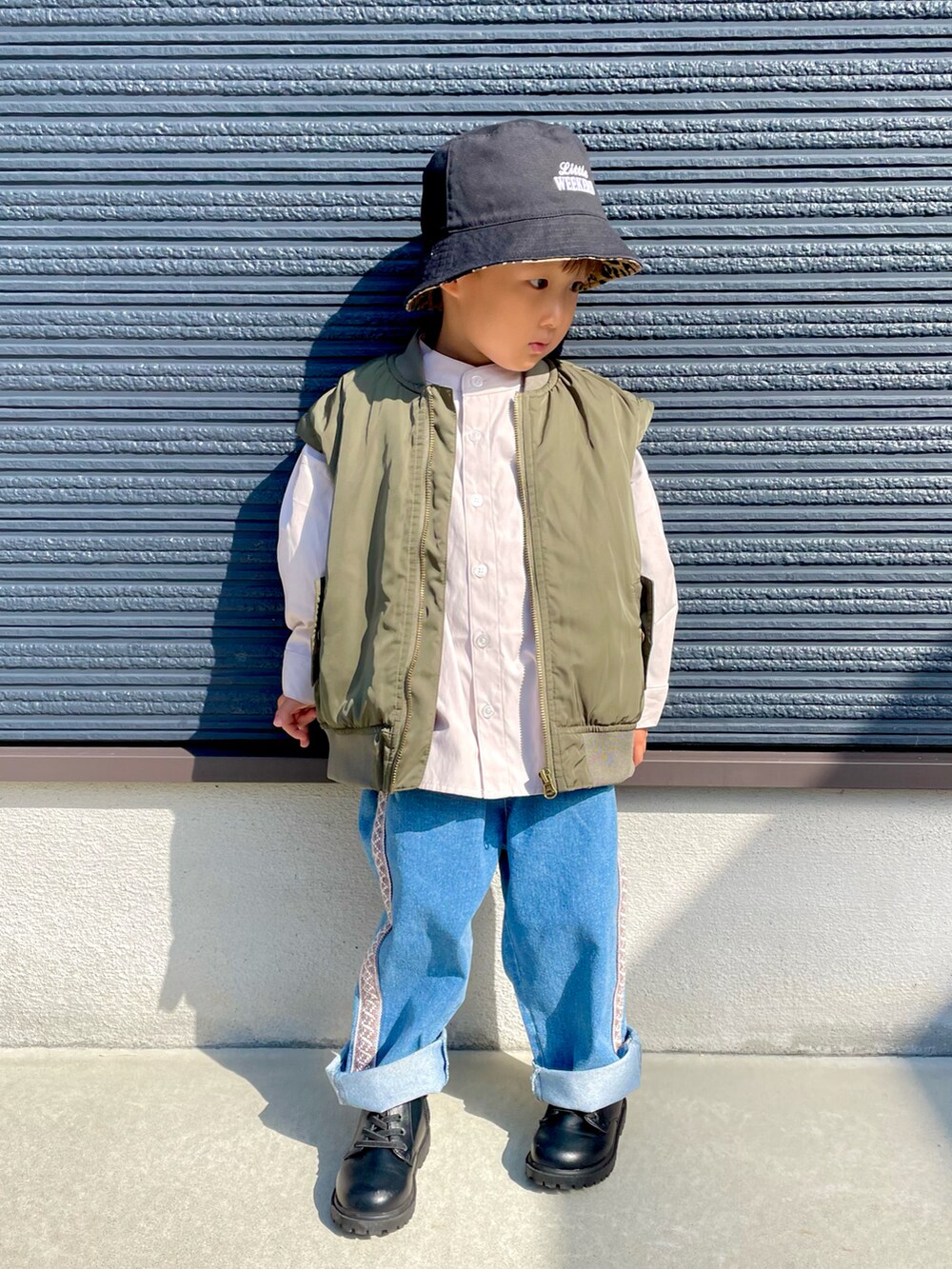 グリーン系のMA-1、ベージュ系のシャツ/ブラウス、ブルー系のデニムパンツを着用したキッズの秋コーディネートの3枚目の写真