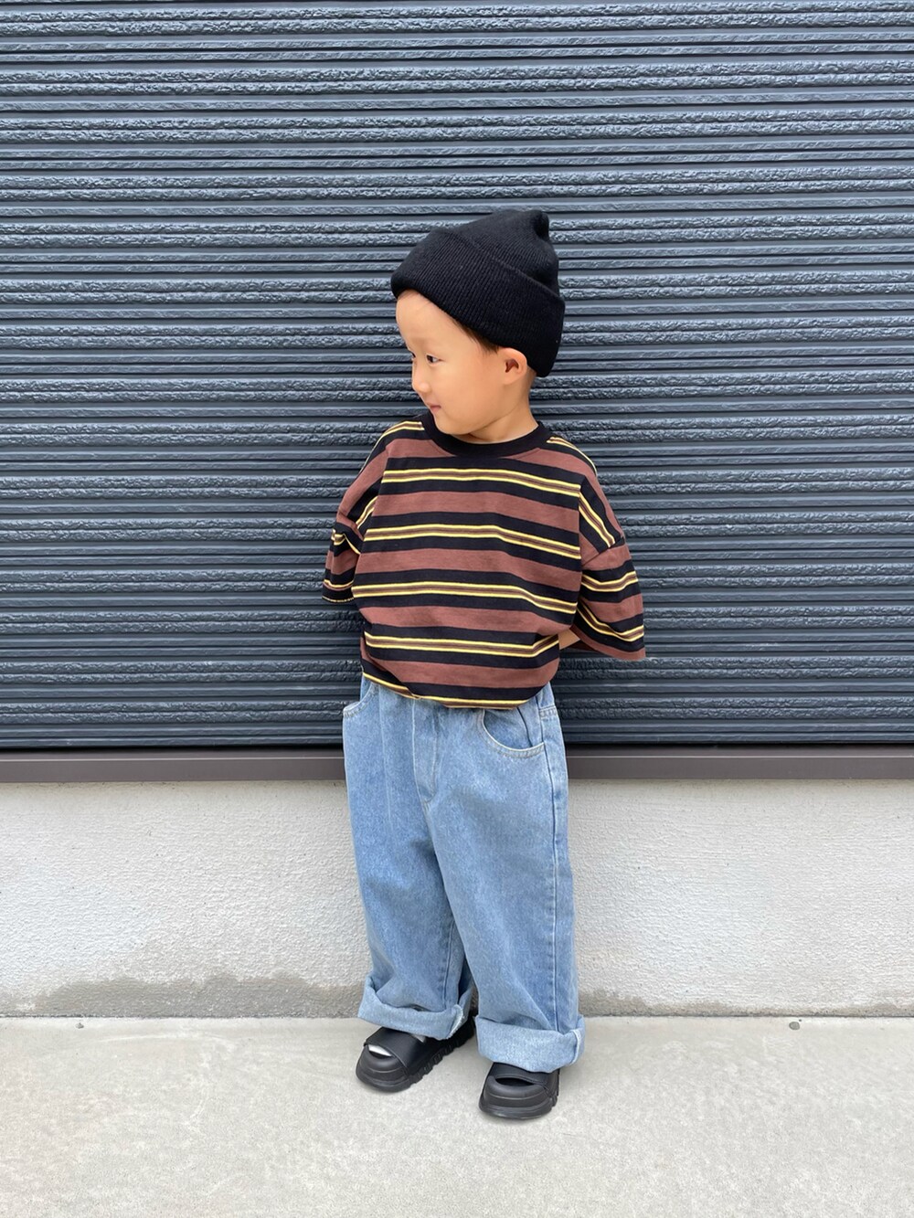 ブラウン系のTシャツ/カットソー、ブルー系のデニムパンツ、ブラック系のサンダルを着用したキッズの夏コーディネートの2枚目の写真