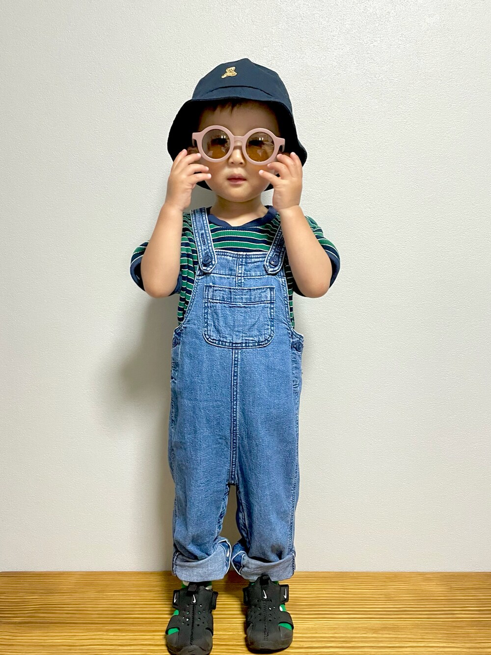 グリーン系のTシャツ/カットソー、ブルー系のサロペット/オーバーオール、ブラック系のサンダルを着用したキッズの夏コーディネートの4枚目の写真