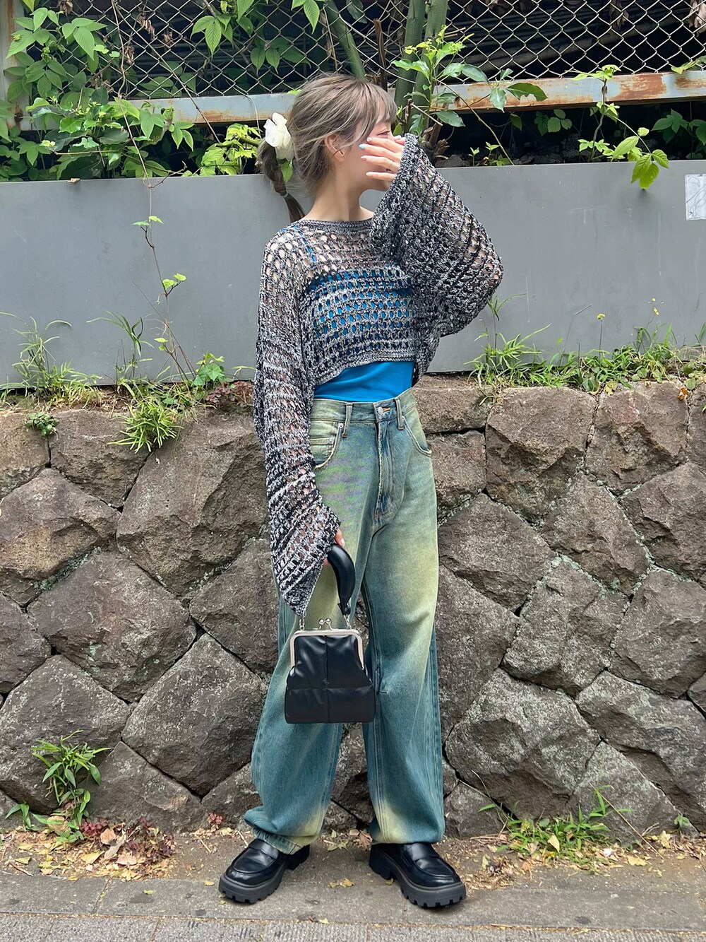 ブルー系のニット/セーター、ブルー系のデニムパンツ、ブラック系のローファーを着用したレディースの夏コーディネートの2枚目の写真