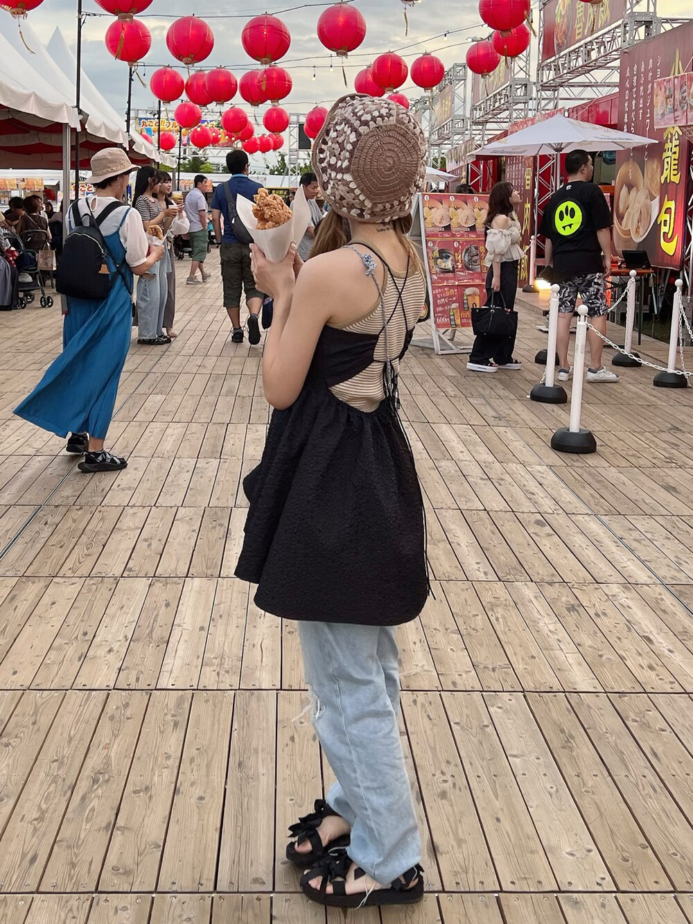 ブルー系のデニムパンツ、ブラック系のサンダル、ブラック系のワンピースを着用したレディースの秋コーディネートの2枚目の写真