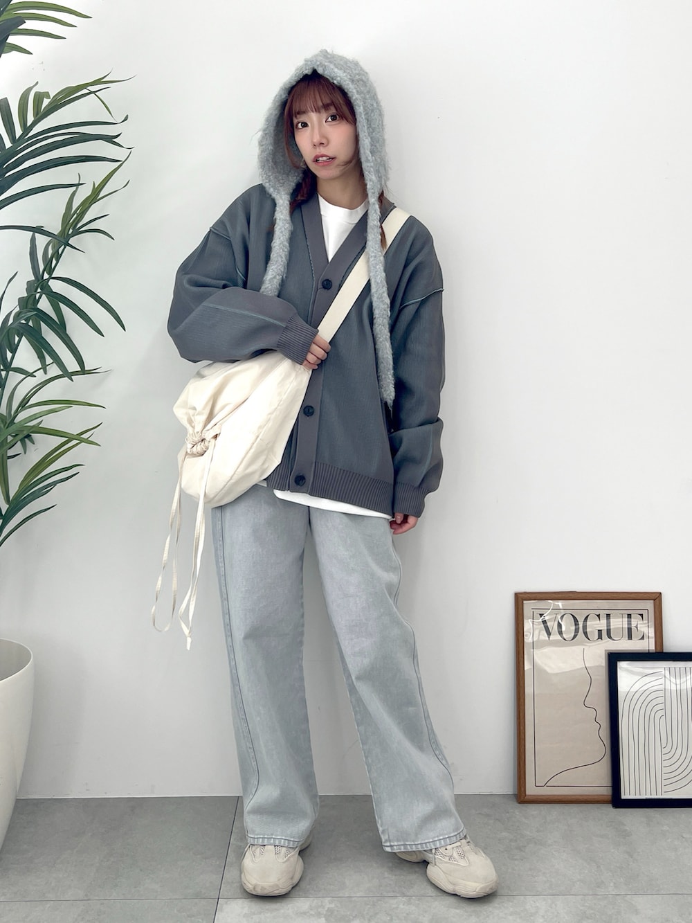 グレー系のカーディガン/ボレロ、グレー系のデニムパンツ、ホワイト系のショルダーバッグを着用したレディースの冬コーディネートの3枚目の写真