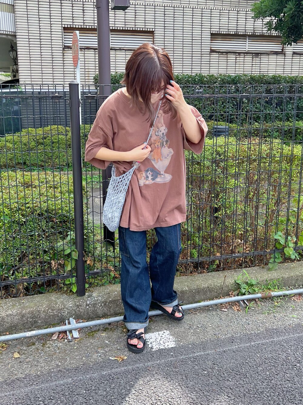 ブラウン系のTシャツ/カットソー、ブルー系のデニムパンツ、ブラック系のサンダルを着用したレディースの秋コーディネートの3枚目の写真