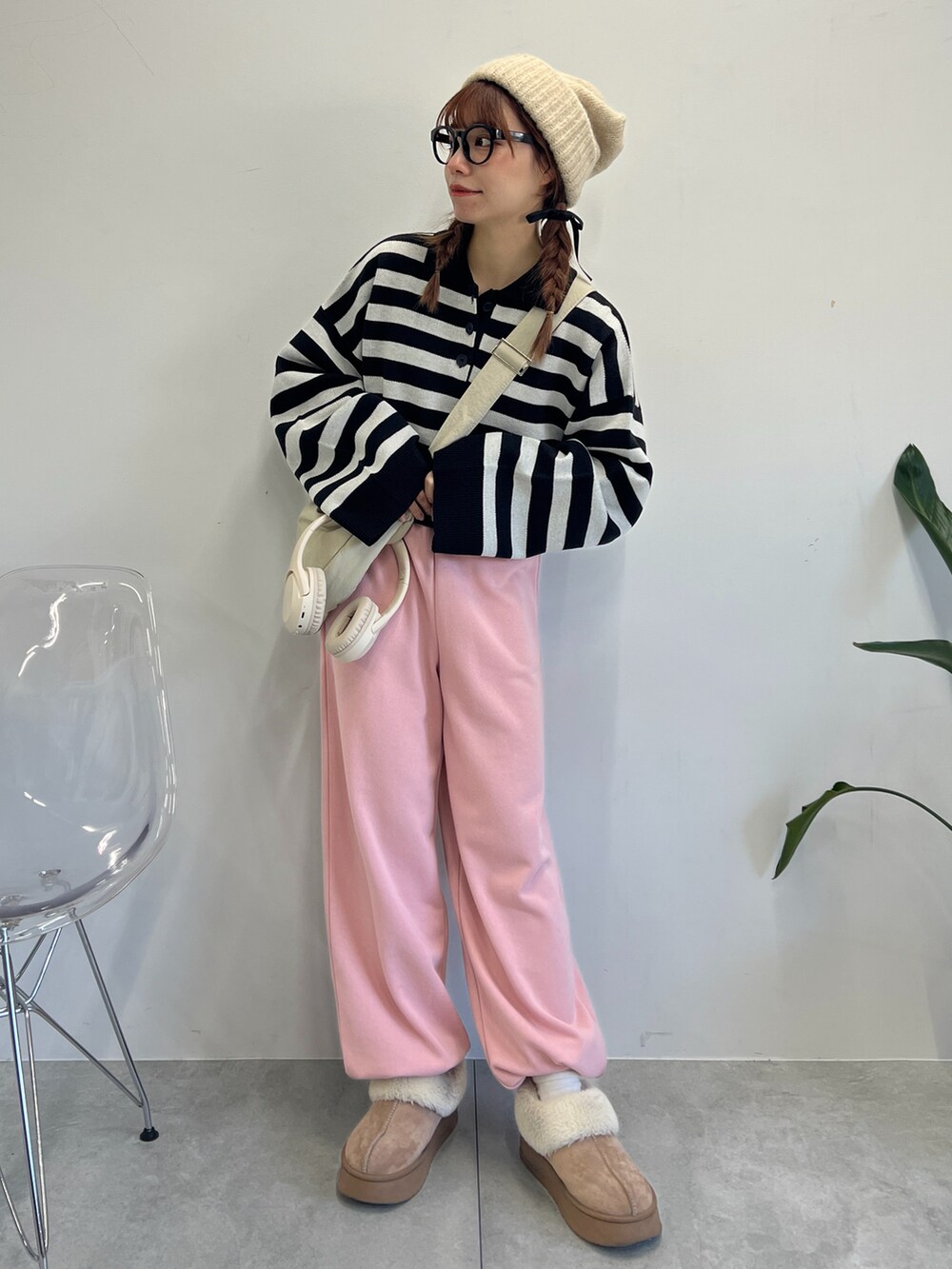 ピンク系のスウェットパンツ、ブラック系のニット/セーター、ホワイト系のショルダーバッグを着用したレディースの冬コーディネートの4枚目の写真