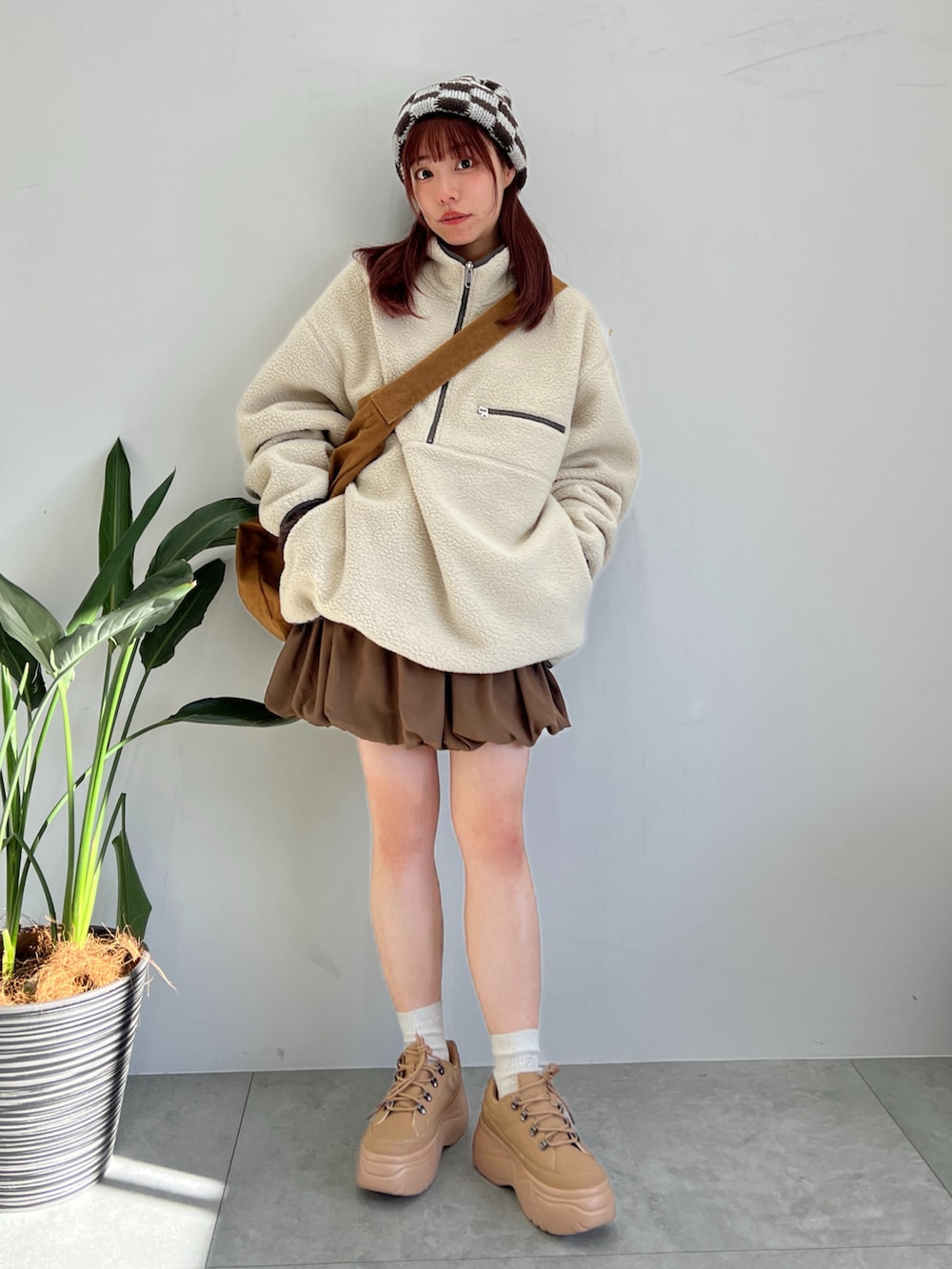 ベージュ系のスウェット、ブラウン系のスカート、イエロー系のショルダーバッグを着用したレディースの冬コーディネートの2枚目の写真