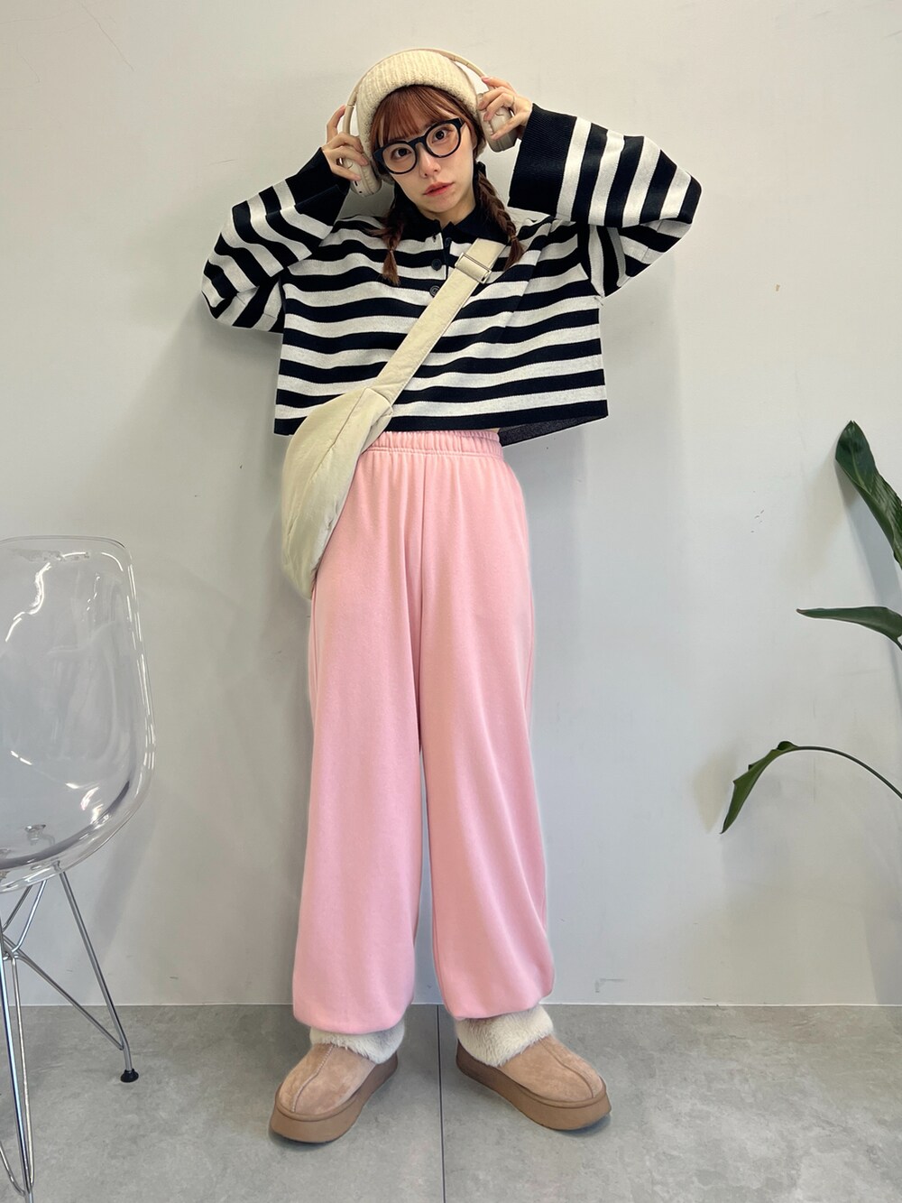 ピンク系のスウェットパンツ、ブラック系のニット/セーター、ホワイト系のショルダーバッグを着用したレディースの冬コーディネートの3枚目の写真