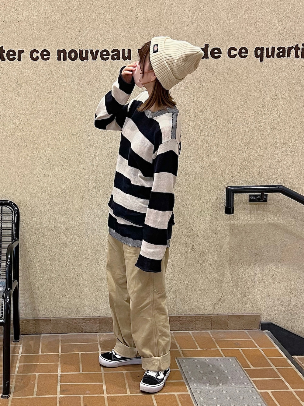ベージュ系のチノパンツ、ブラック系のスニーカー、ホワイト系のニットキャップ/ビーニーを着用したレディースの秋コーディネートの2枚目の写真