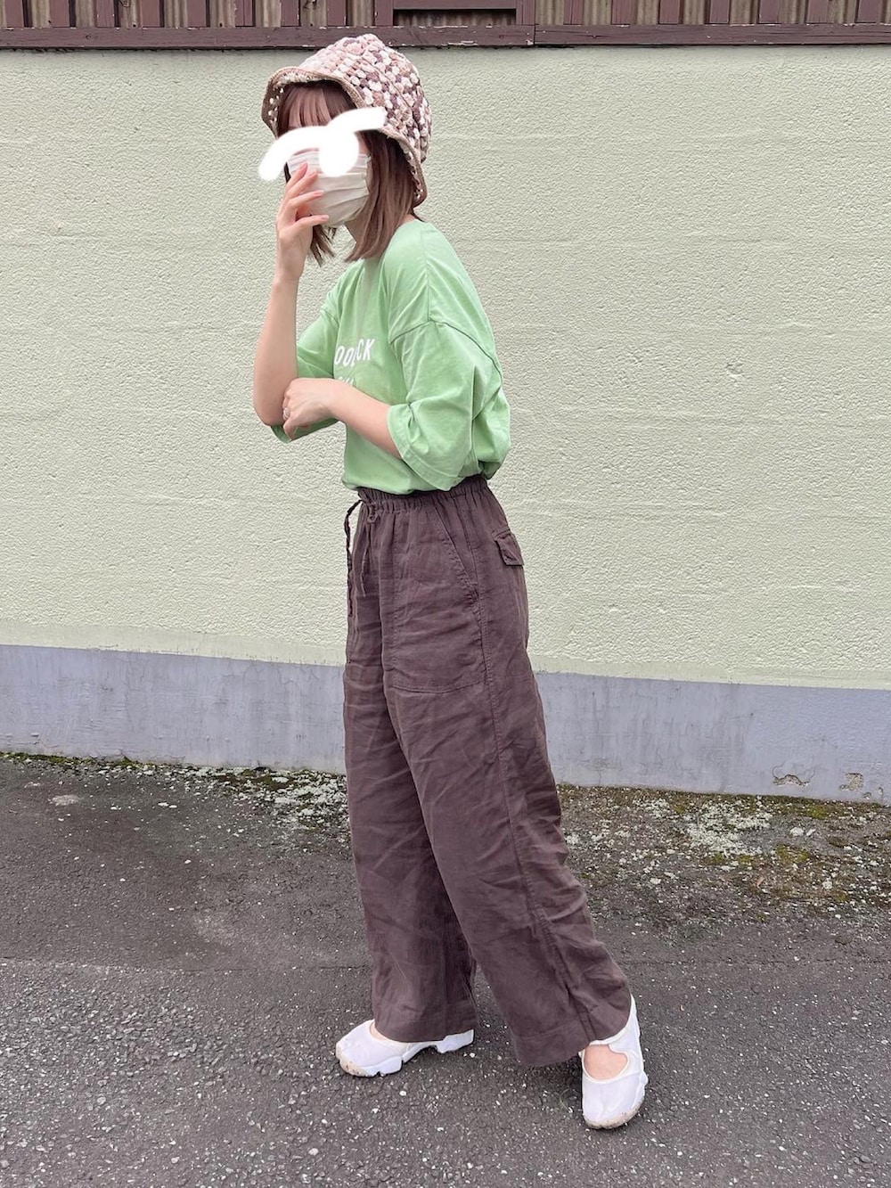 グリーン系のTシャツ/カットソー、ブラウン系のその他パンツ、ベージュ系のサンダルを着用したレディースの秋コーディネートの2枚目の写真