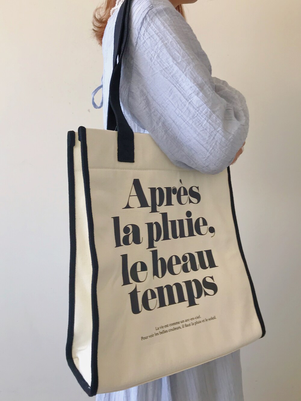 ブラック系のパンプス、ブルー系のワンピース、ホワイト系のTシャツ/カットソーを着用したレディースの春コーディネートの3枚目の写真