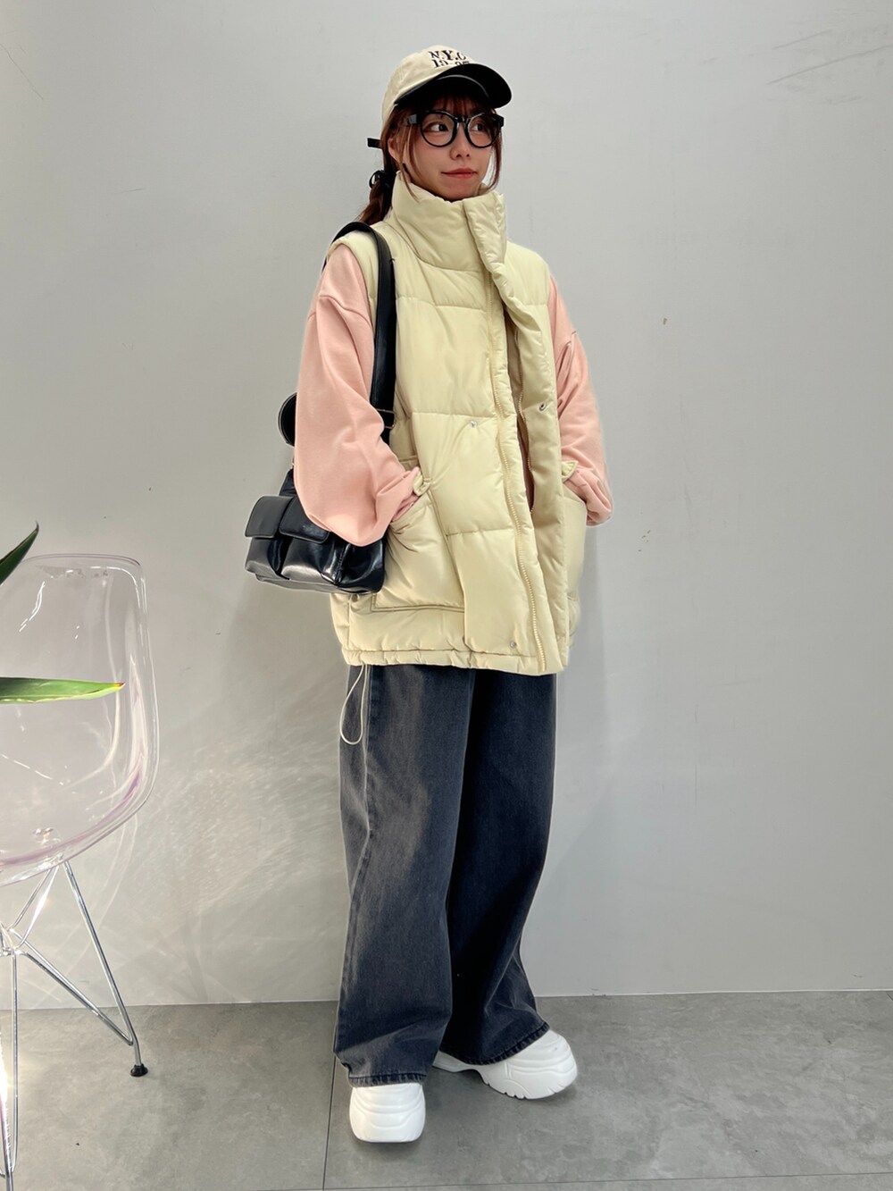 ブラック系のデニムパンツ、ピンク系のスウェット、ホワイト系のダウンベストを着用したレディースの冬コーディネートの2枚目の写真