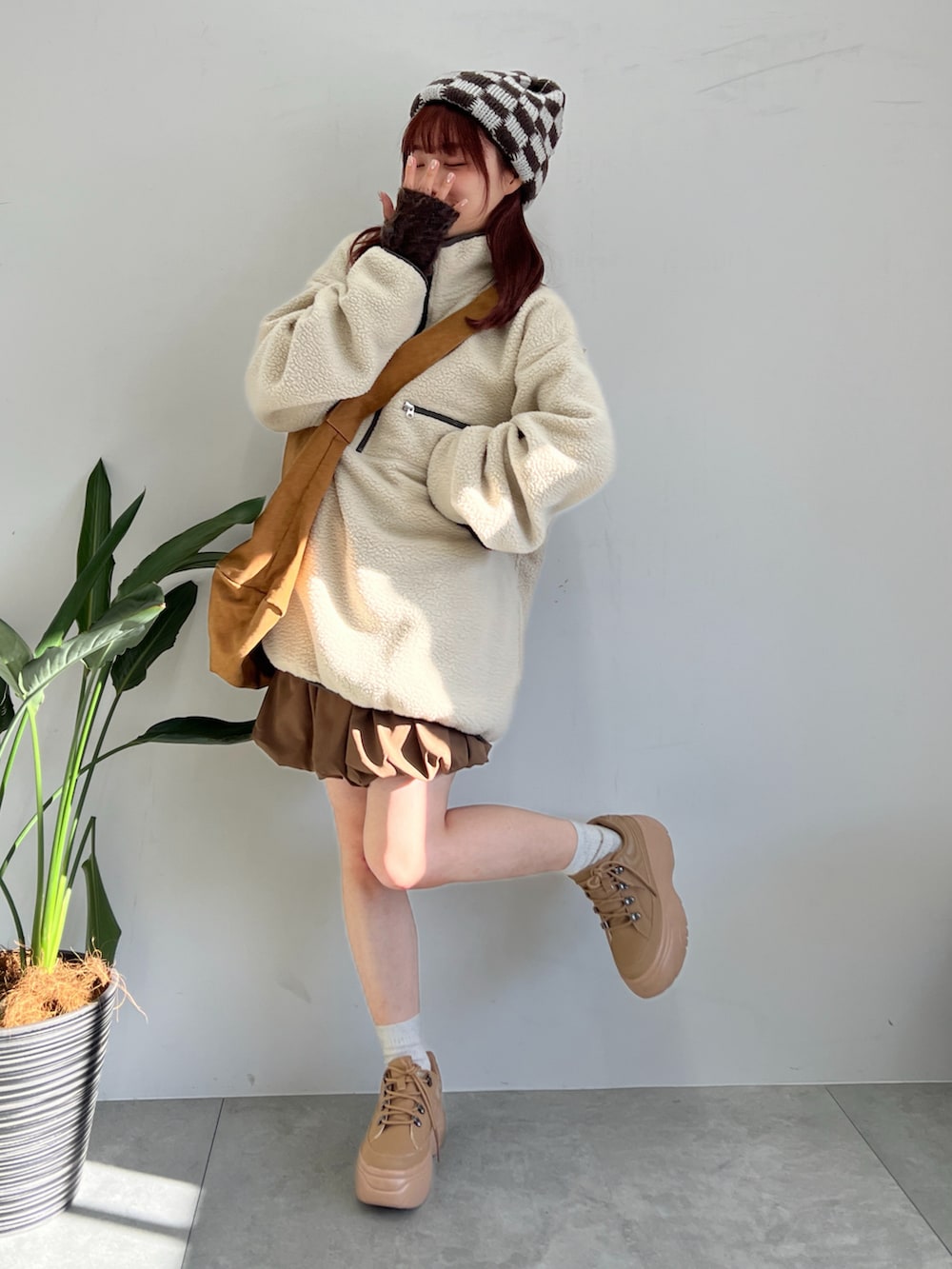 ベージュ系のスウェット、ブラウン系のスカート、イエロー系のショルダーバッグを着用したレディースの冬コーディネートの3枚目の写真