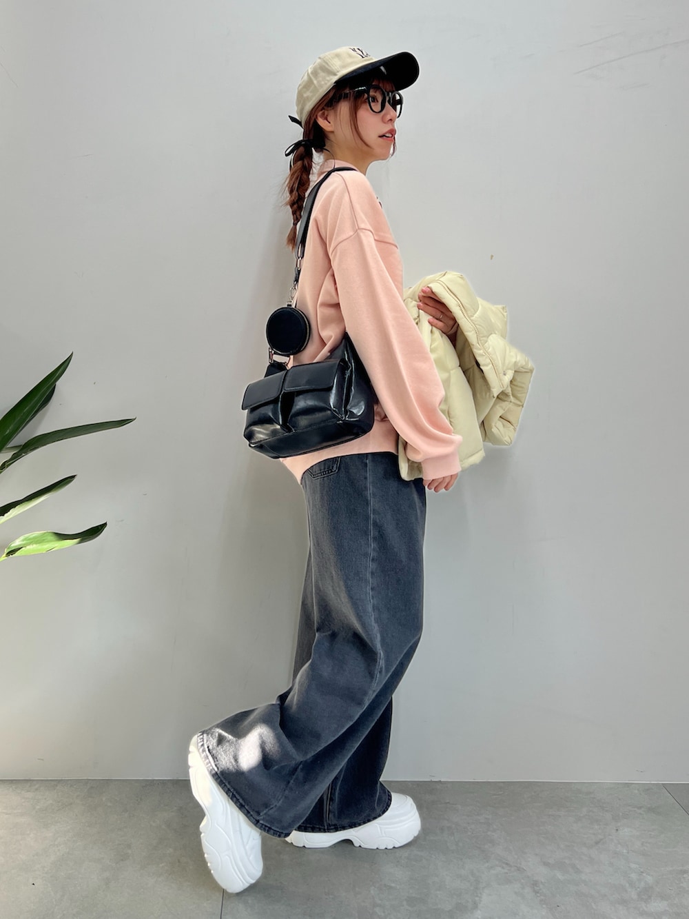 ブラック系のデニムパンツ、ピンク系のスウェット、ホワイト系のダウンベストを着用したレディースの冬コーディネートの5枚目の写真
