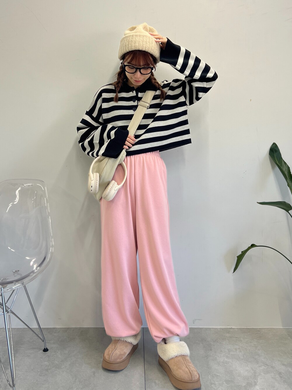 ピンク系のスウェットパンツ、ブラック系のニット/セーター、ホワイト系のショルダーバッグを着用したレディースの冬コーディネートの5枚目の写真