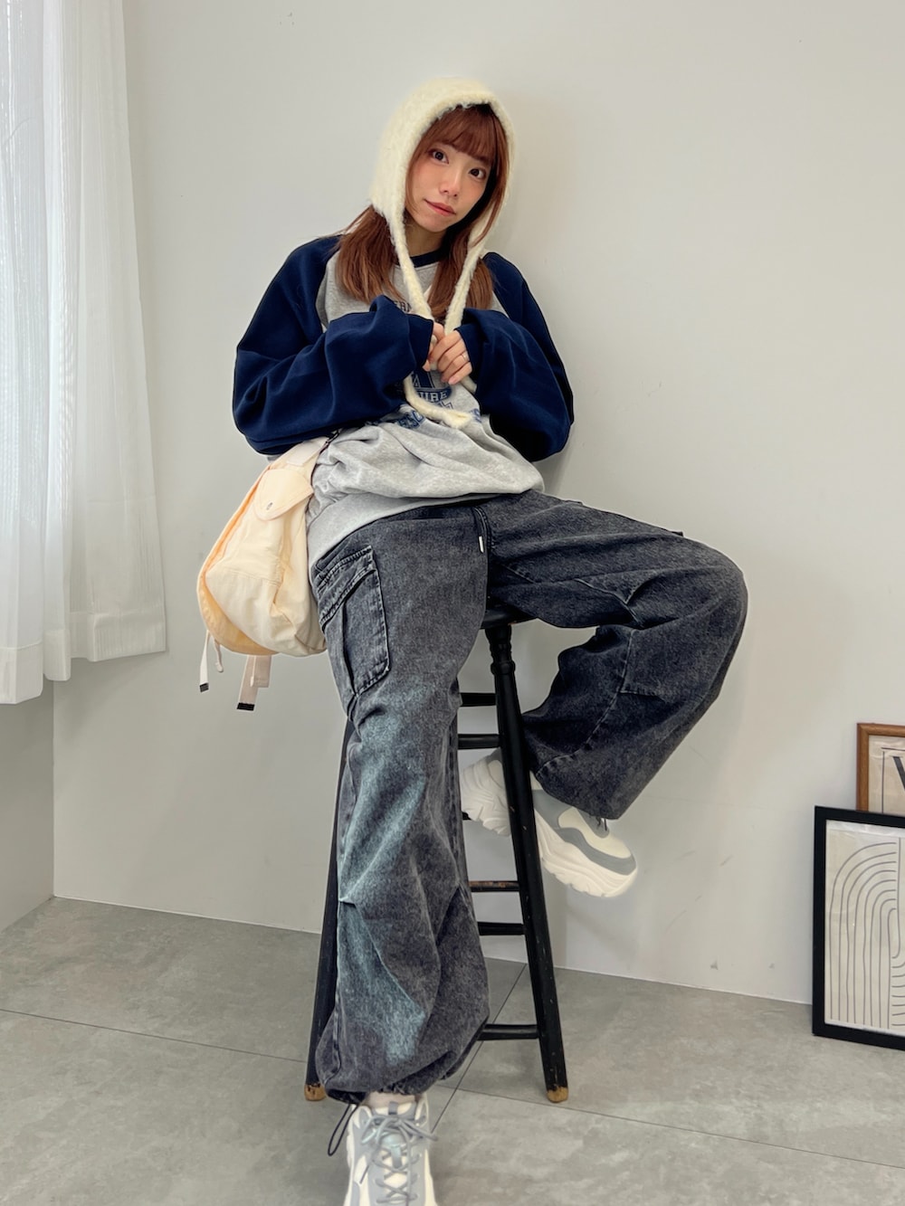 ブルー系のスウェット、ブラック系のデニムパンツ、グレー系のスニーカーを着用したレディースの冬コーディネートの2枚目の写真