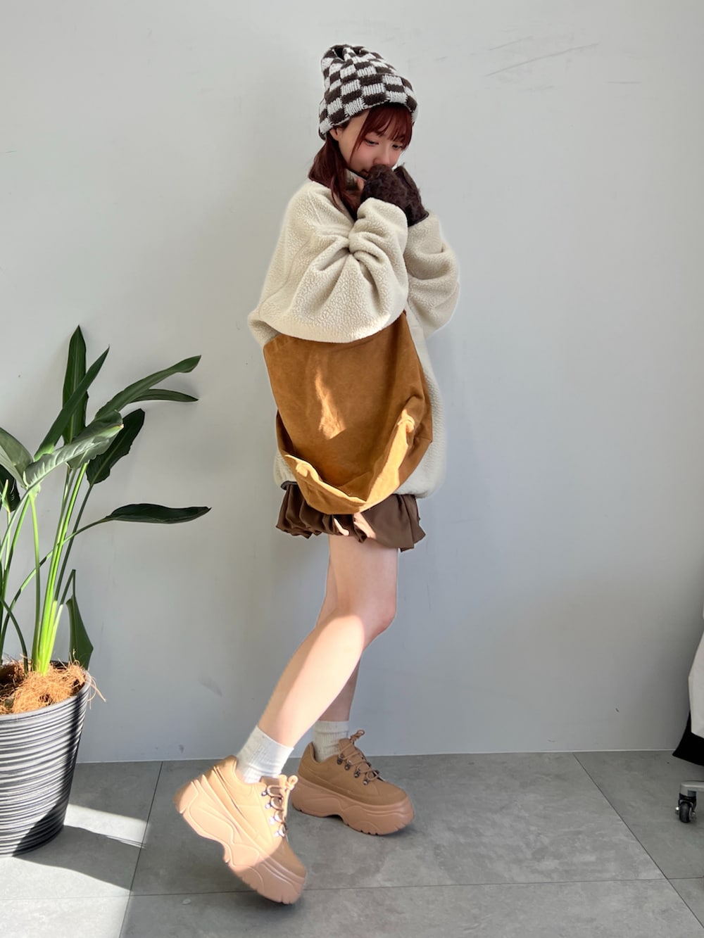 ベージュ系のスウェット、ブラウン系のスカート、イエロー系のショルダーバッグを着用したレディースの冬コーディネートの4枚目の写真