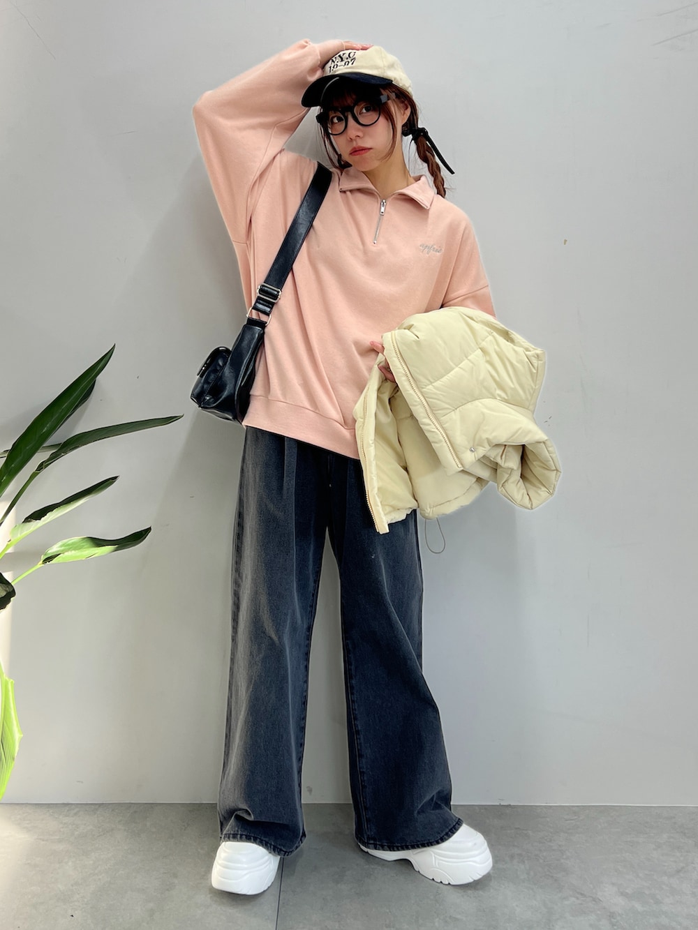 ブラック系のデニムパンツ、ピンク系のスウェット、ホワイト系のダウンベストを着用したレディースの冬コーディネートの4枚目の写真