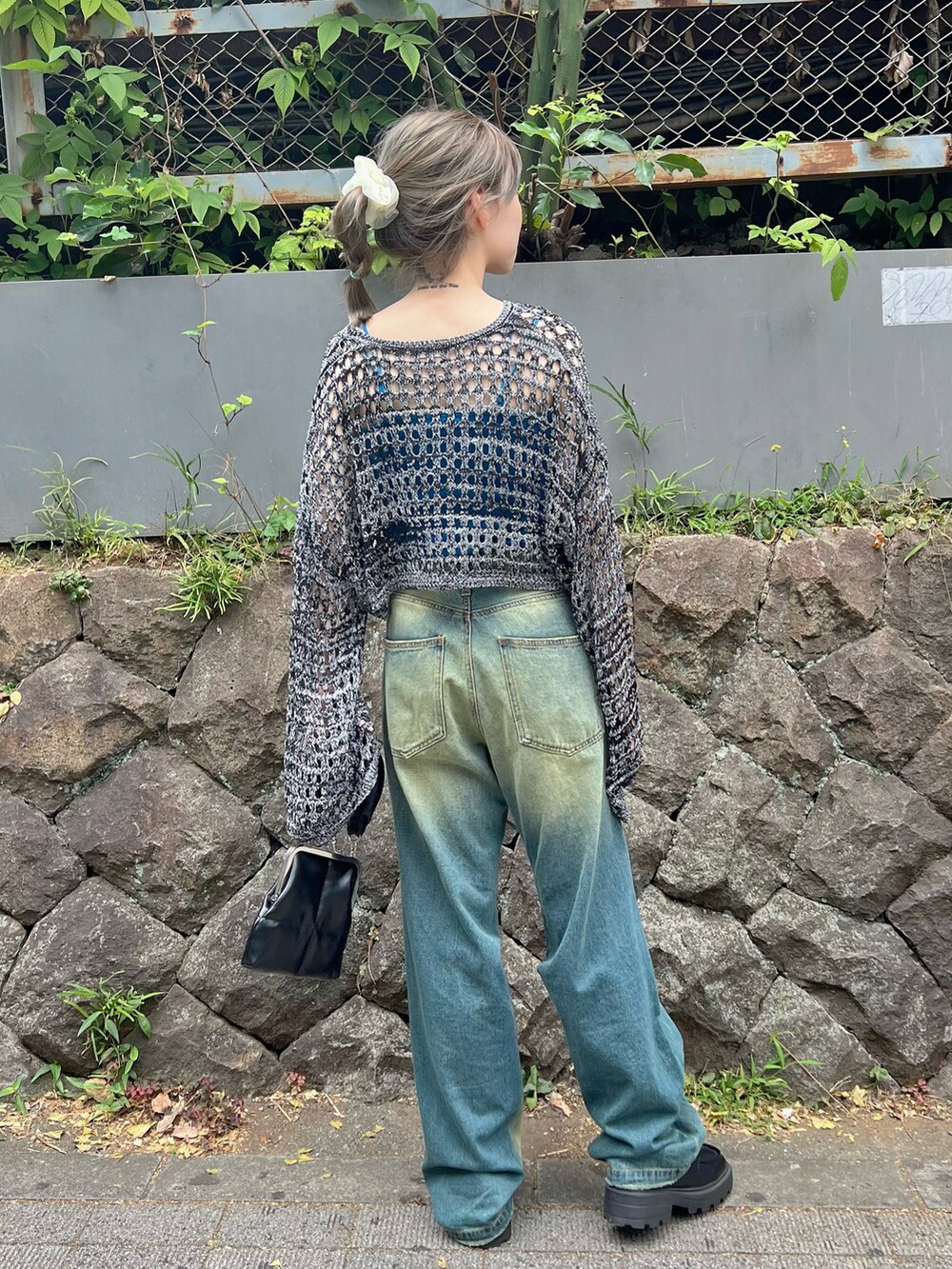 ブルー系のニット/セーター、ブルー系のデニムパンツ、ブラック系のローファーを着用したレディースの夏コーディネートの3枚目の写真