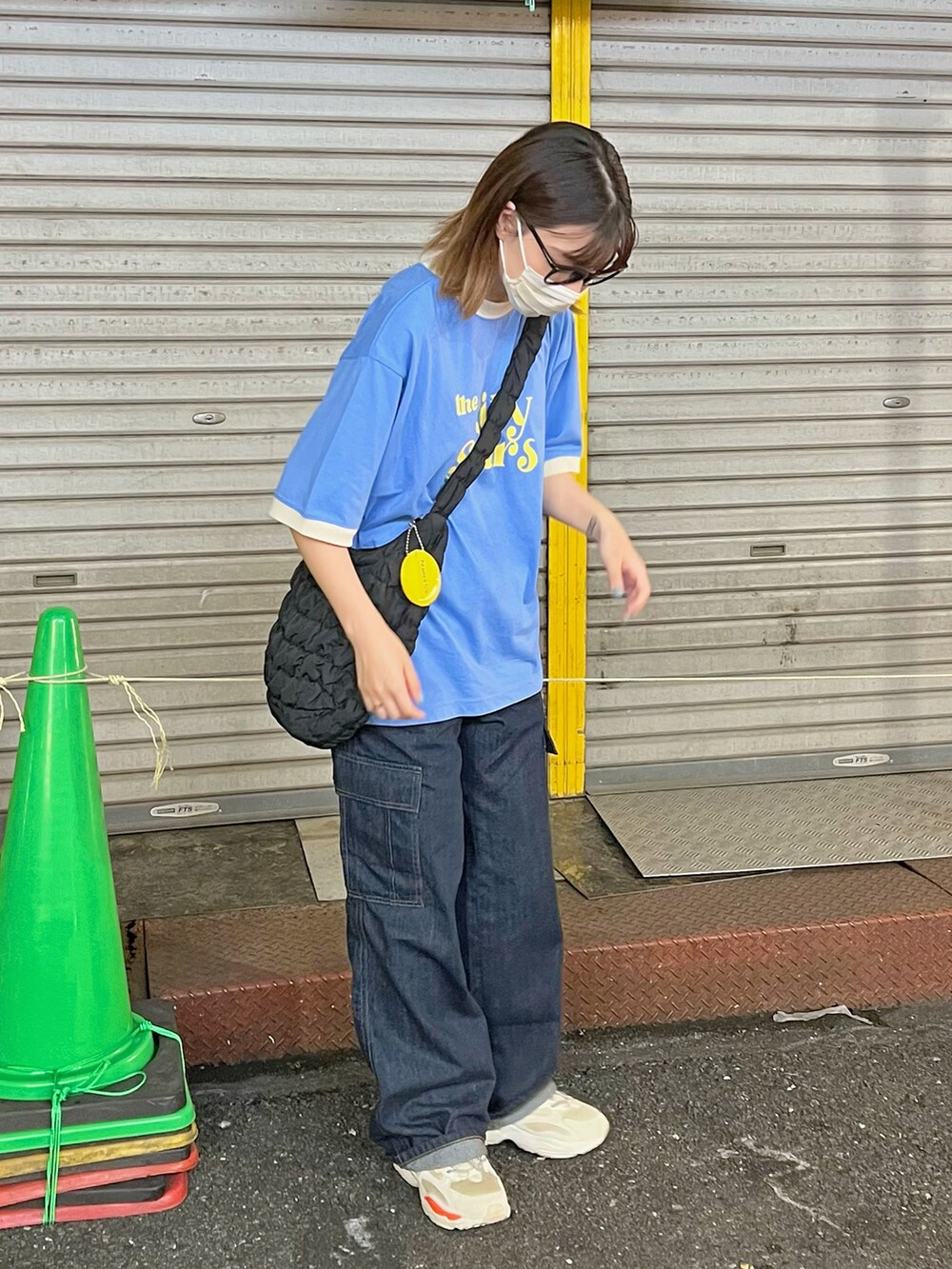 ブルー系のデニムパンツ、ブラック系のショルダーバッグ、ブルー系のTシャツ/カットソーを着用したレディースの秋コーディネートの2枚目の写真
