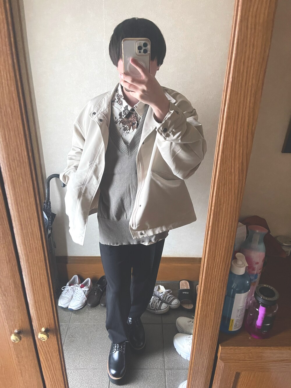 ブラウン系のドレスシューズ、ブラック系のスラックス、グレー系のベストを着用したメンズの春コーディネートの2枚目の写真