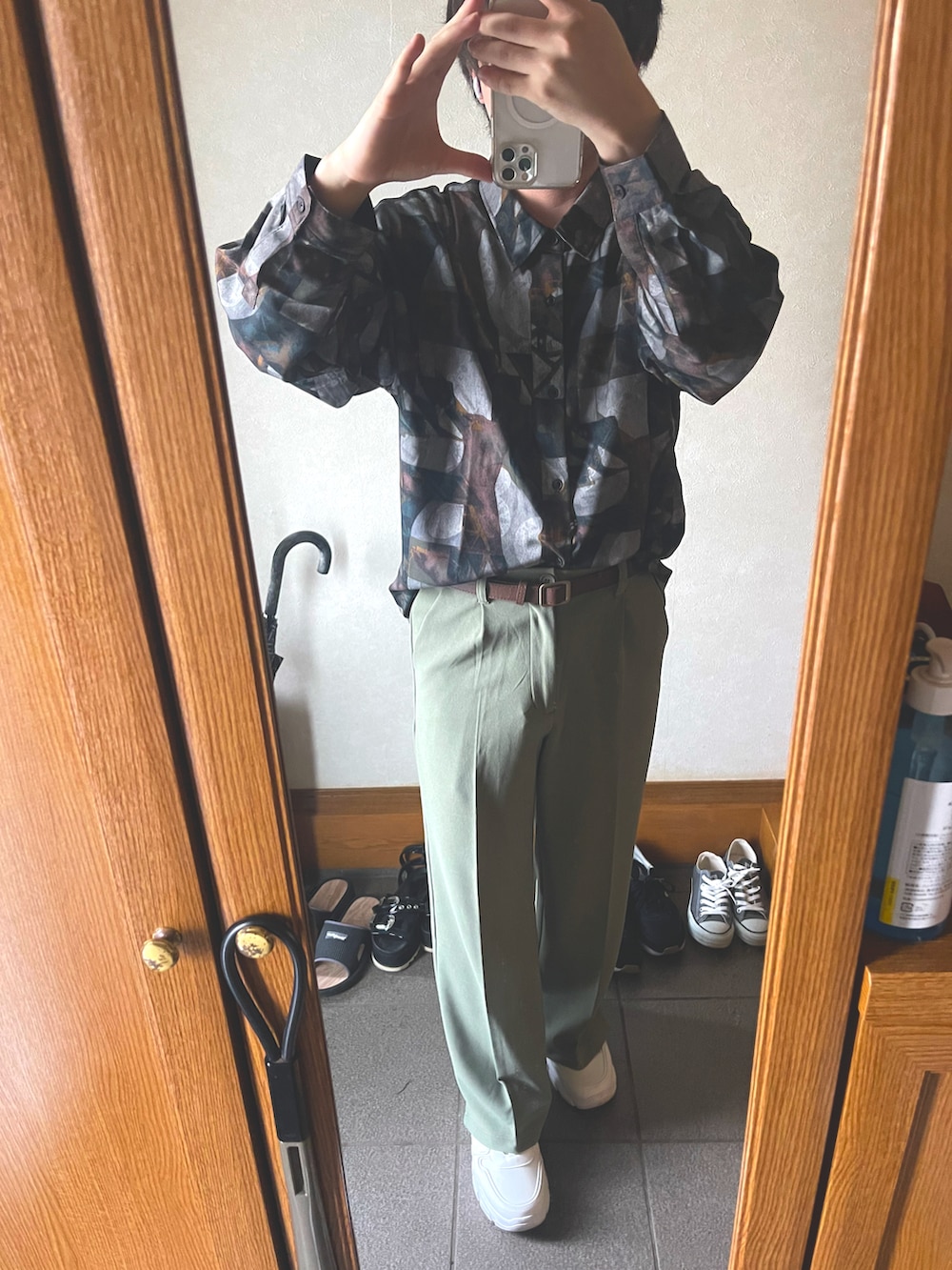 グリーン系のスラックス、ブラウン系のシャツ/ブラウス、ホワイト系のスニーカーを着用したメンズの秋コーディネートの2枚目の写真