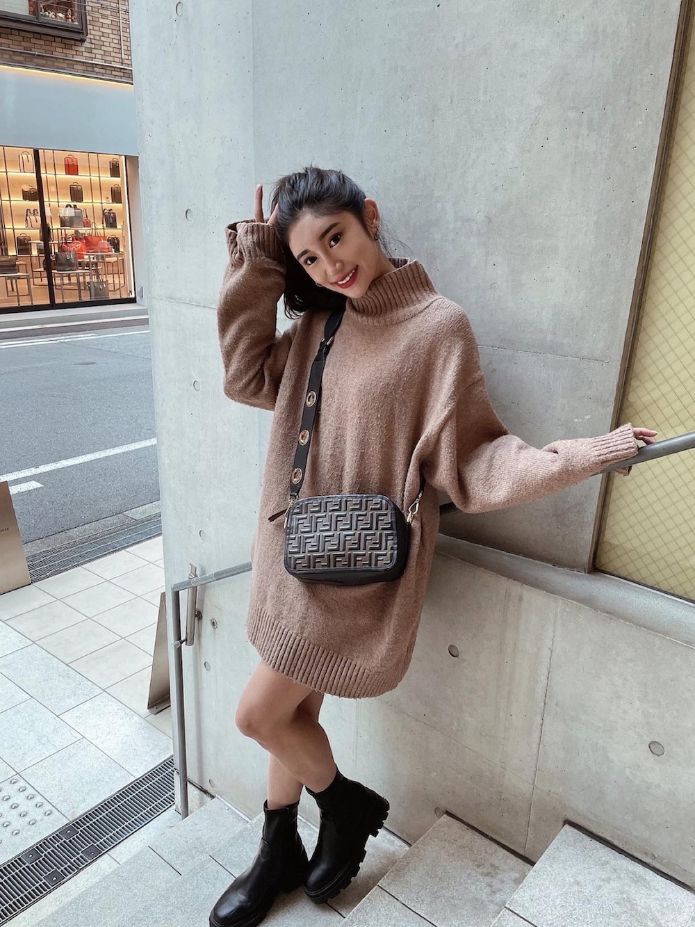 ブラック系のショルダーバッグ、ブラック系のブーツ、ブラウン系のニット/セーターを着用したレディースの秋コーディネートの2枚目の写真