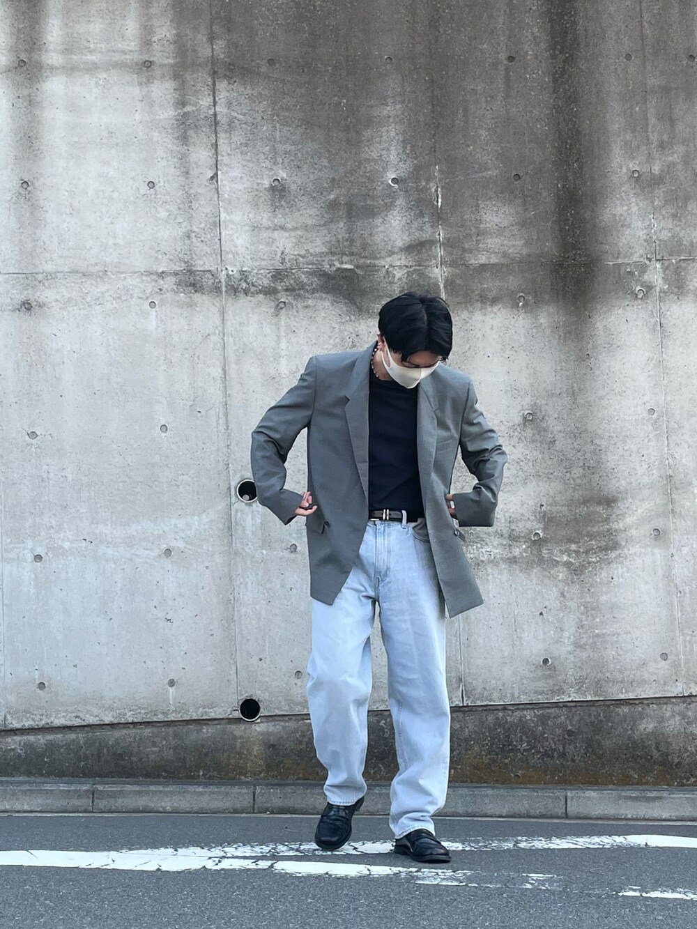 グレー系のテーラードジャケット、ブルー系のデニムパンツ、ブラック系のローファーを着用したメンズの春コーディネートの3枚目の写真