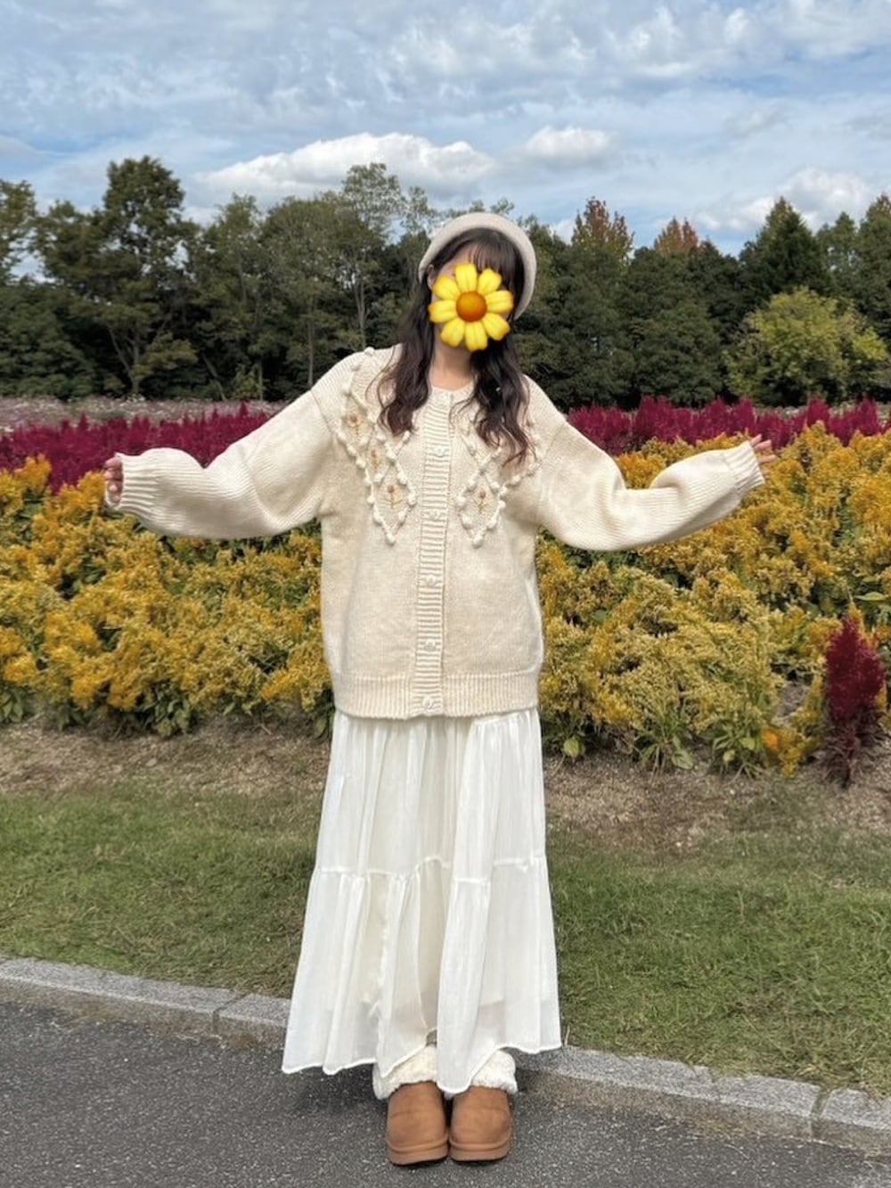 ベージュ系のカーディガン/ボレロ、ホワイト系のスカート、ブラウン系のシューズを着用したレディースの秋コーディネートの2枚目の写真