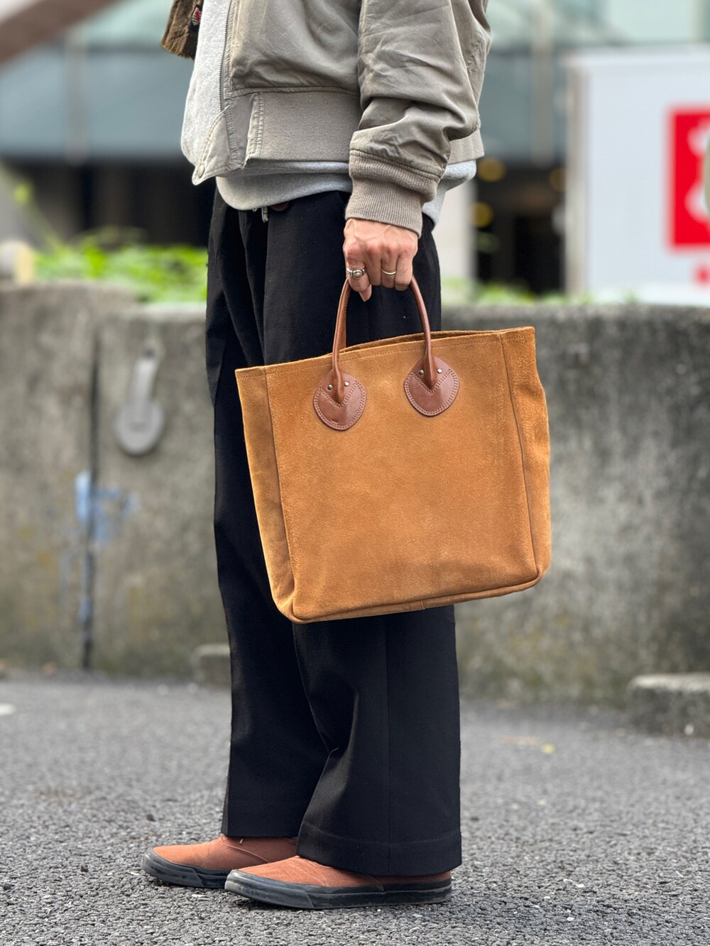 ブルー系のスラックス、ブルー系のスニーカー、グリーン系のハットを着用したメンズの秋コーディネートの4枚目の写真