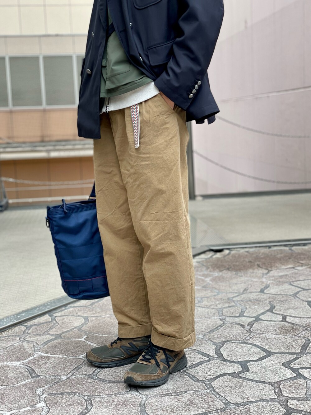 ブラウン系のチノパンツ、ベージュ系のスウェット、ブルー系のキャップを着用したメンズの春コーディネートの4枚目の写真