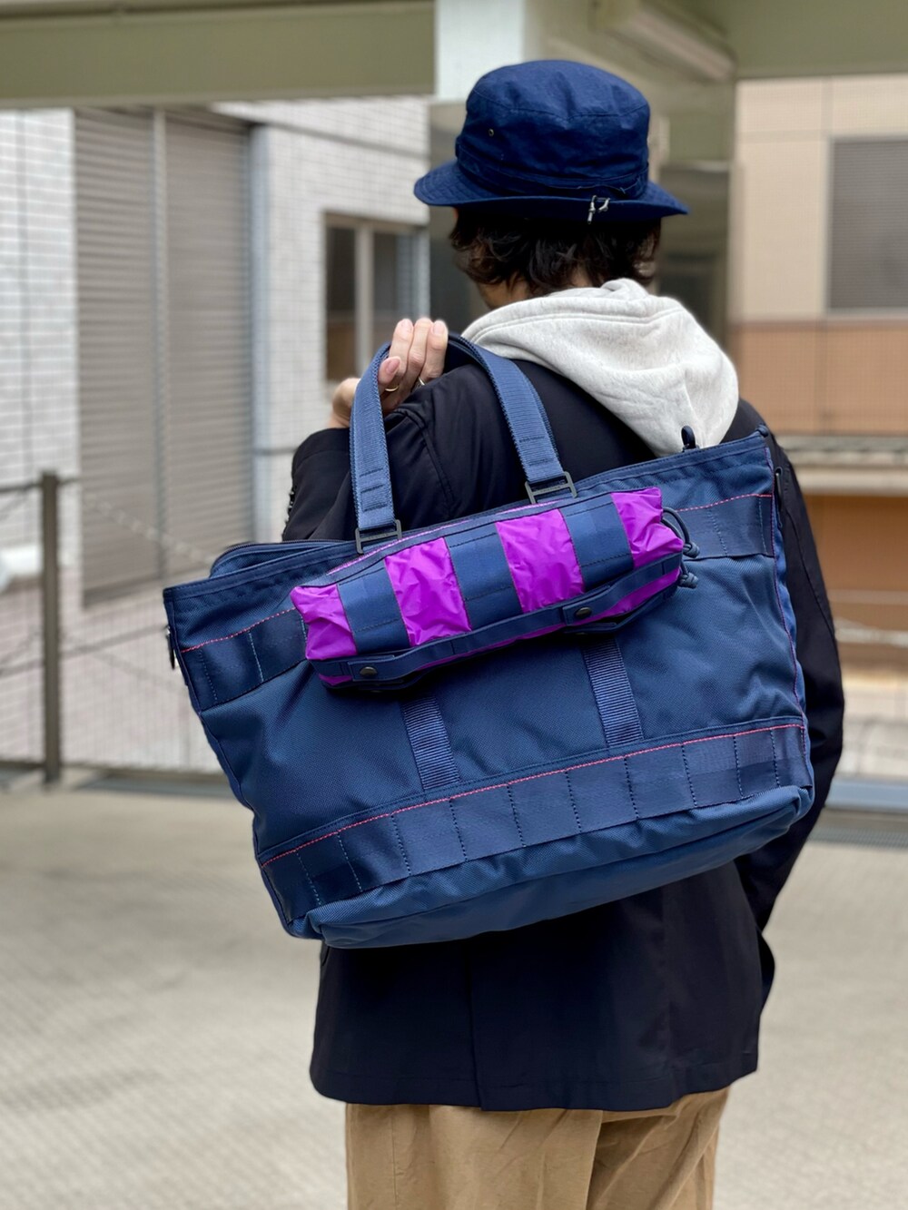 ブラウン系のチノパンツ、ベージュ系のスウェット、ブルー系のキャップを着用したメンズの春コーディネートの3枚目の写真