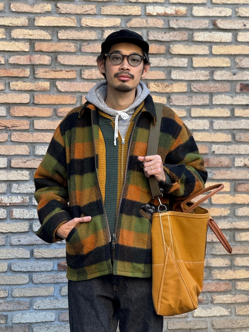 ブラック系のデニムパンツ、グリーン系のブルゾン、グリーン系のニット/セーターを着用したメンズの冬コーディネートの2枚目の写真