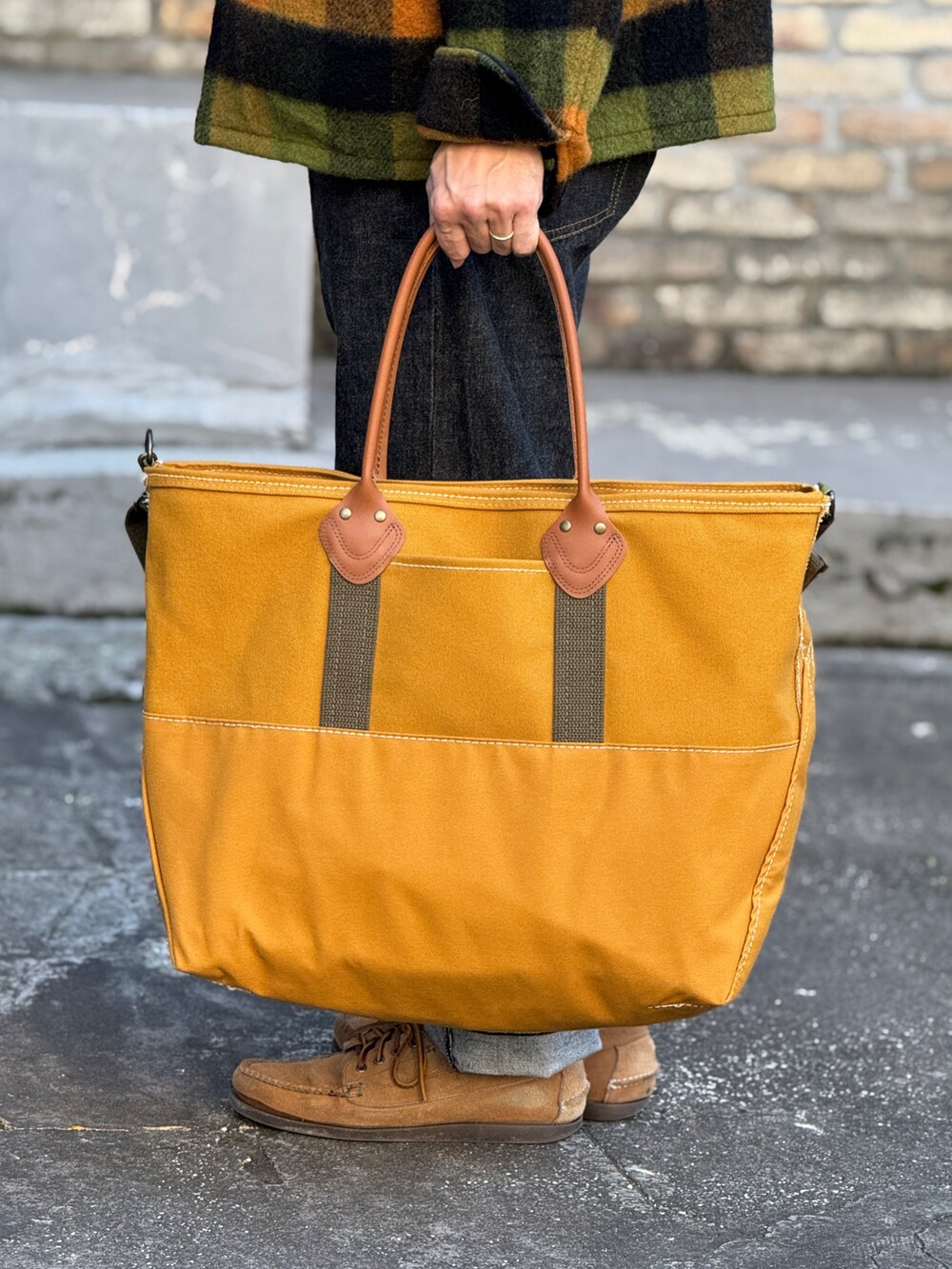 ブラック系のデニムパンツ、グリーン系のブルゾン、グリーン系のニット/セーターを着用したメンズの冬コーディネートの4枚目の写真