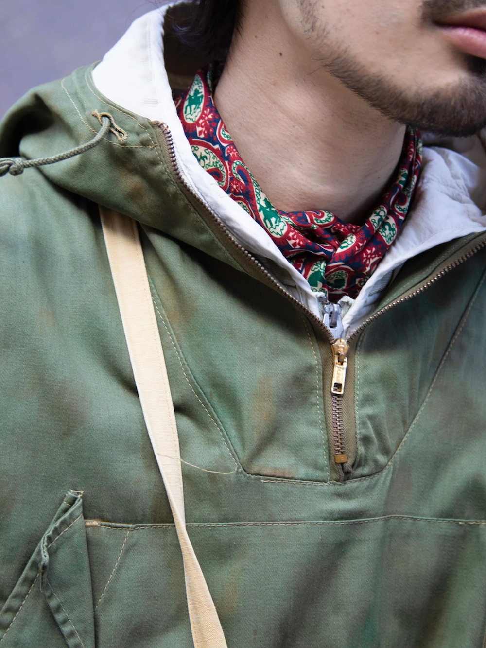 グリーン系のマウンテンパーカー、ブラウン系のモカシン/デッキシューズ、その他のハットを着用したメンズの春コーディネートの3枚目の写真