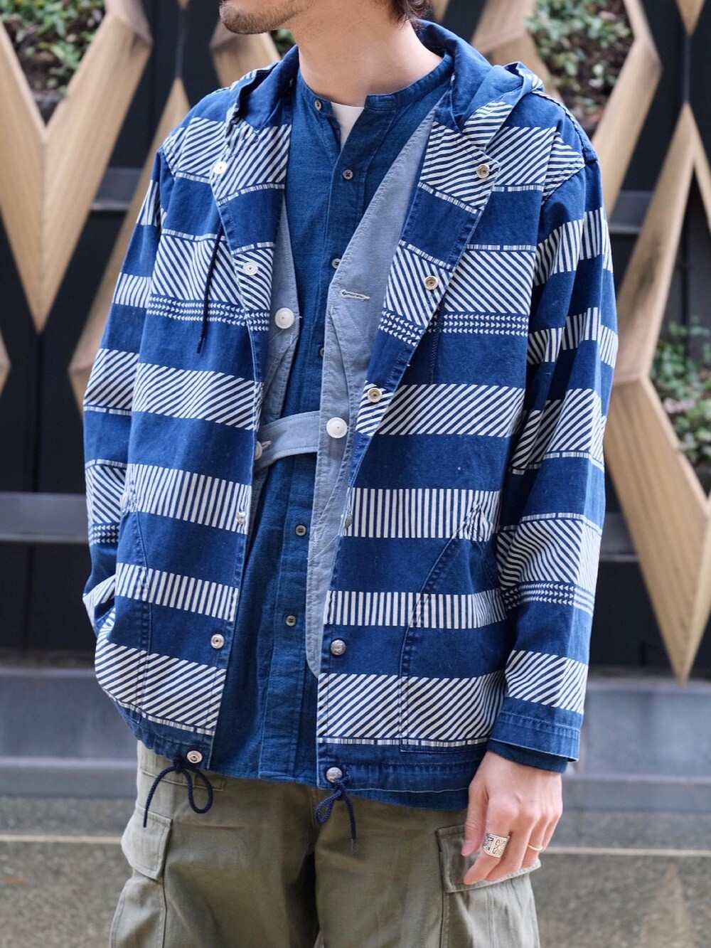 グリーン系のパンツ、その他のブルゾン、ブルー系のハットを着用したメンズの春コーディネートの3枚目の写真