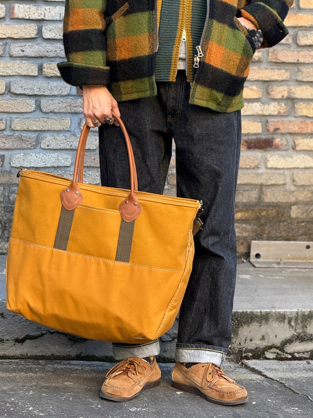 ブラック系のデニムパンツ、グリーン系のブルゾン、グリーン系のニット/セーターを着用したメンズの冬コーディネートの3枚目の写真