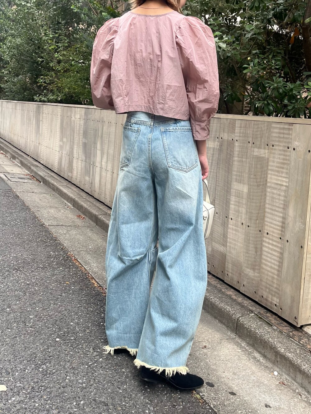 ブルー系のデニムパンツ、ピンク系のシャツ/ブラウス、ホワイト系のボストンバッグを着用したレディースの春コーディネートの2枚目の写真