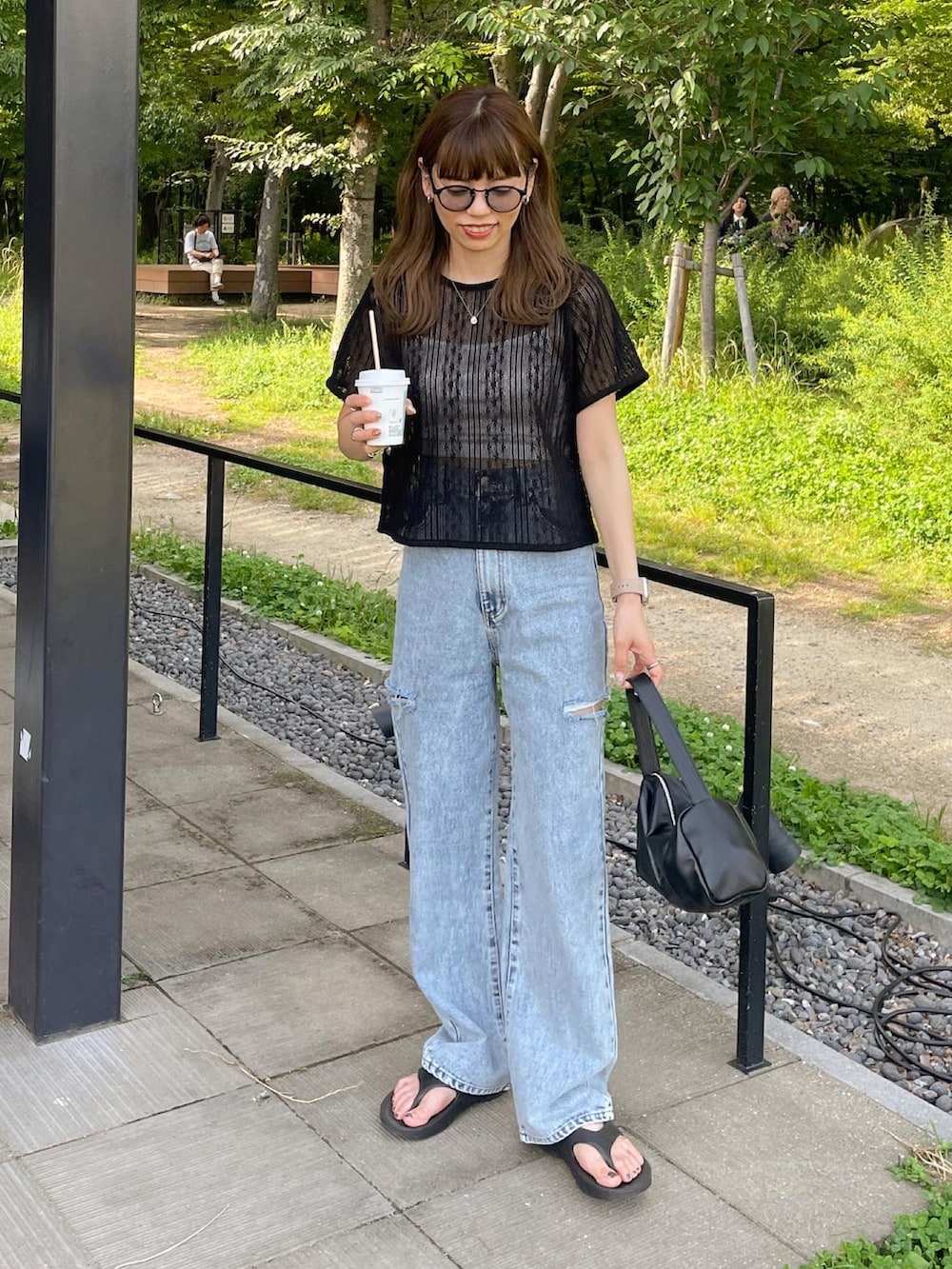 ブラック系のTシャツ/カットソー、ブルー系のデニムパンツを着用したレディースの夏コーディネートの2枚目の写真