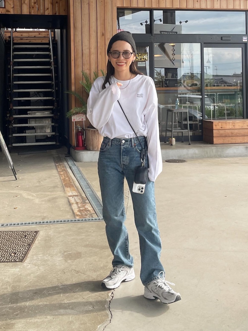 ホワイト系のTシャツ/カットソー、ブルー系のデニムパンツ、ホワイト系のスニーカーを着用したレディースの秋コーディネートの2枚目の写真