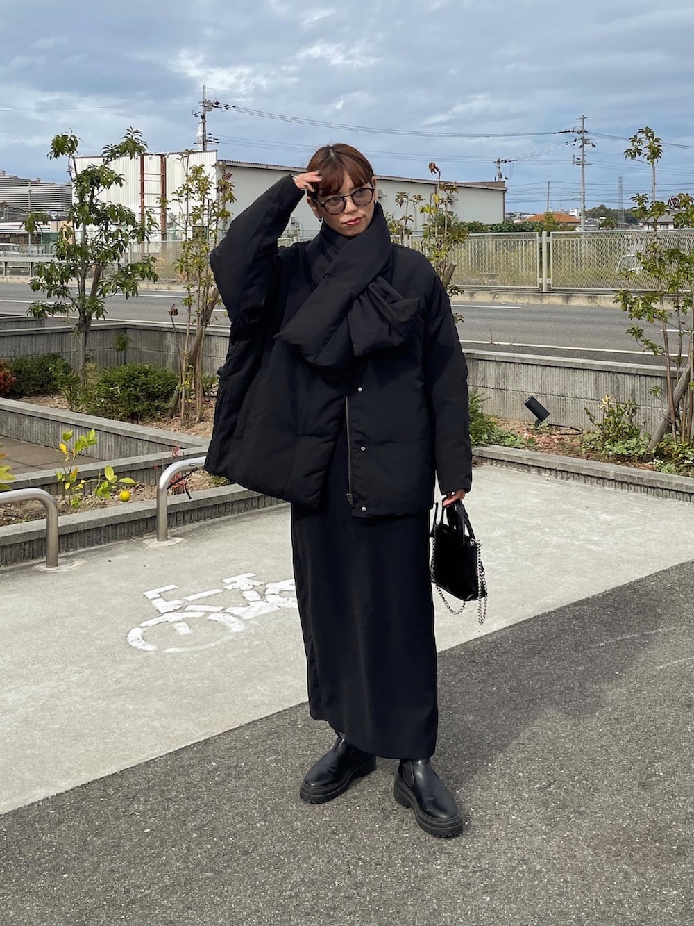 ブラック系のダウンジャケット/コート、ブラック系のスカート、ブラック系のショルダーバッグを着用したレディースの秋コーディネートの3枚目の写真