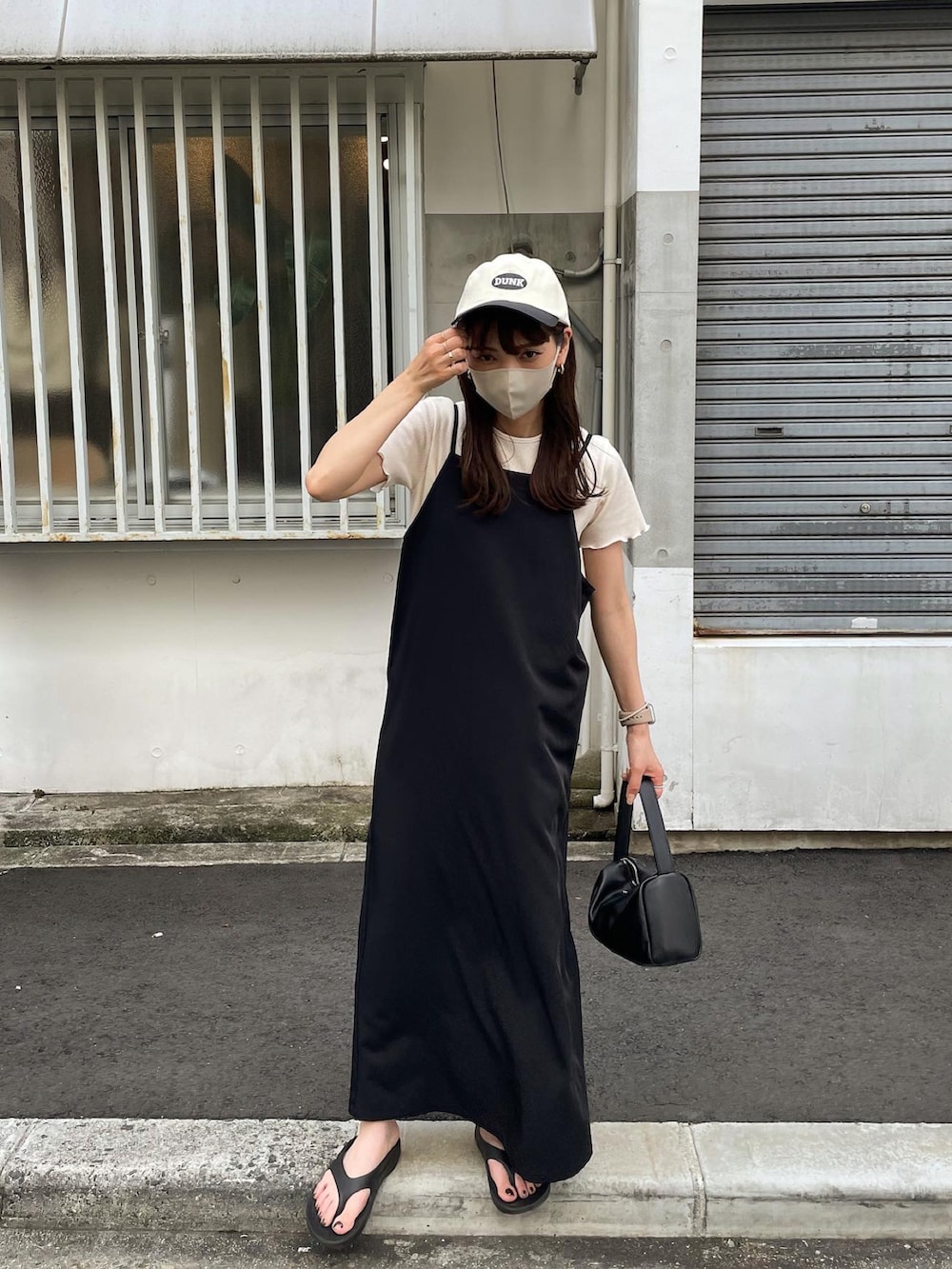 ホワイト系のTシャツ/カットソー、ブラック系のワンピース、ブラック系のサンダルを着用したレディースの夏コーディネートの4枚目の写真