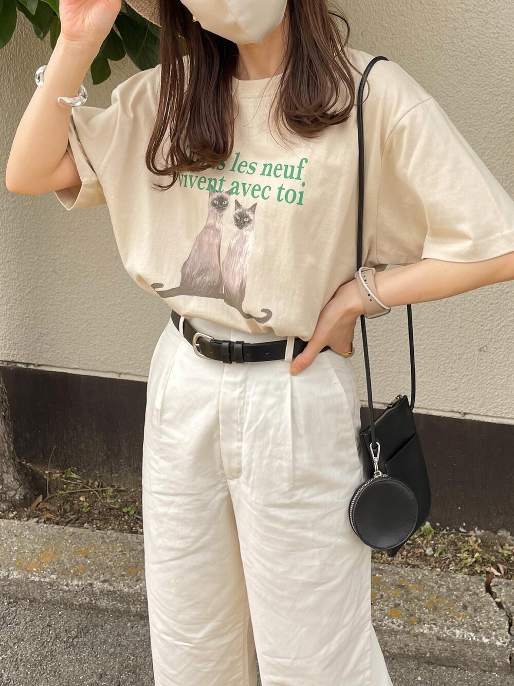 ベージュ系のTシャツ/カットソー、ブラック系のショルダーバッグ、ホワイト系のサンダルを着用したレディースの夏コーディネートの3枚目の写真