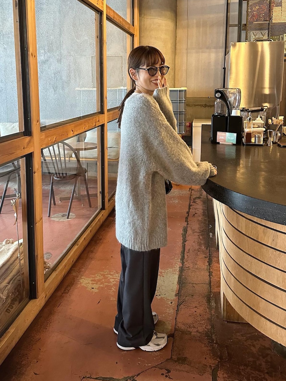 グレー系のカーディガン/ボレロ、グレー系のスラックス、ホワイト系のスニーカーを着用したレディースの秋コーディネートの5枚目の写真