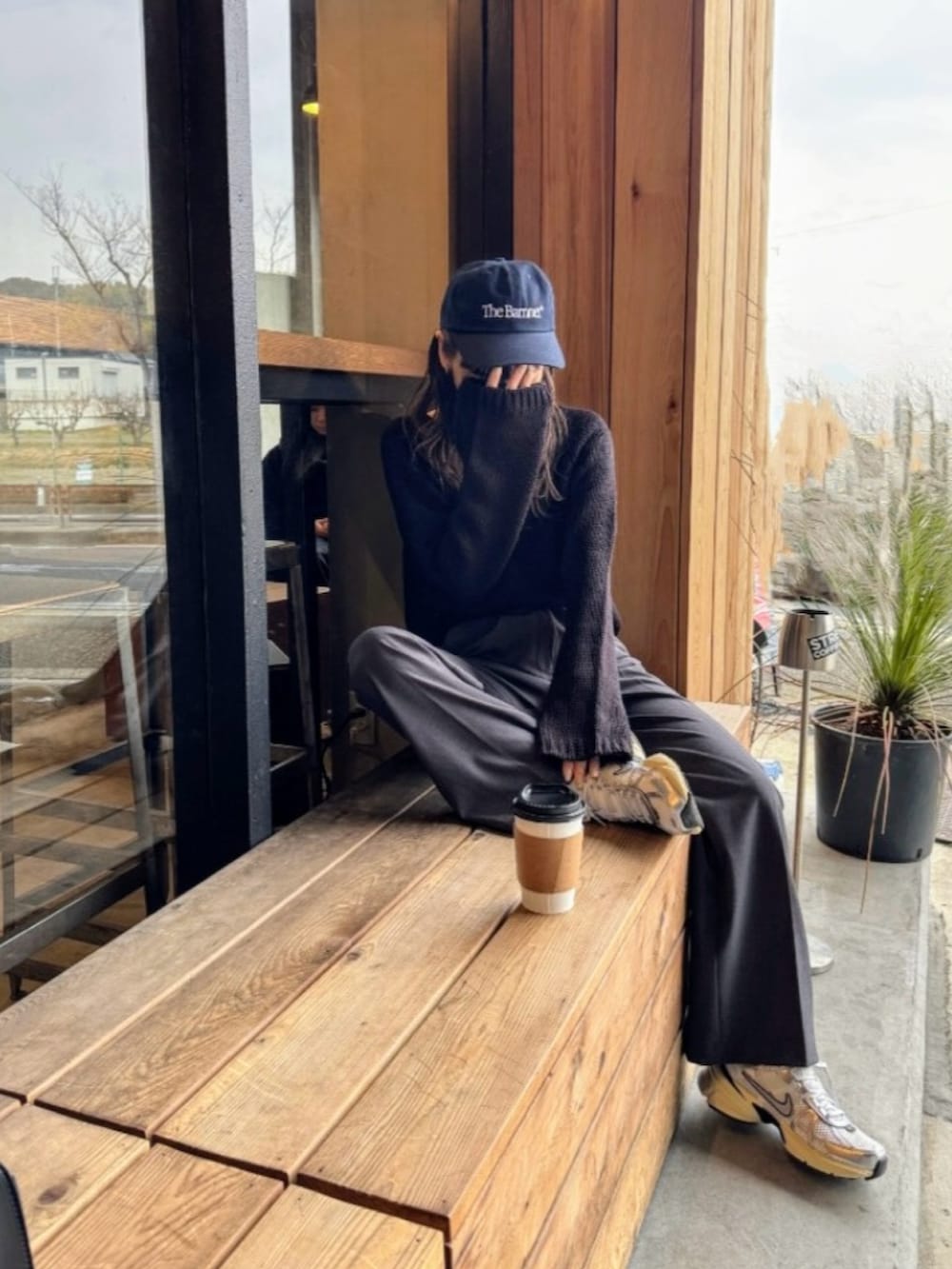 ブラック系のニット/セーター、グレー系のスラックス、ホワイト系のスニーカーを着用したレディースの冬コーディネートの4枚目の写真